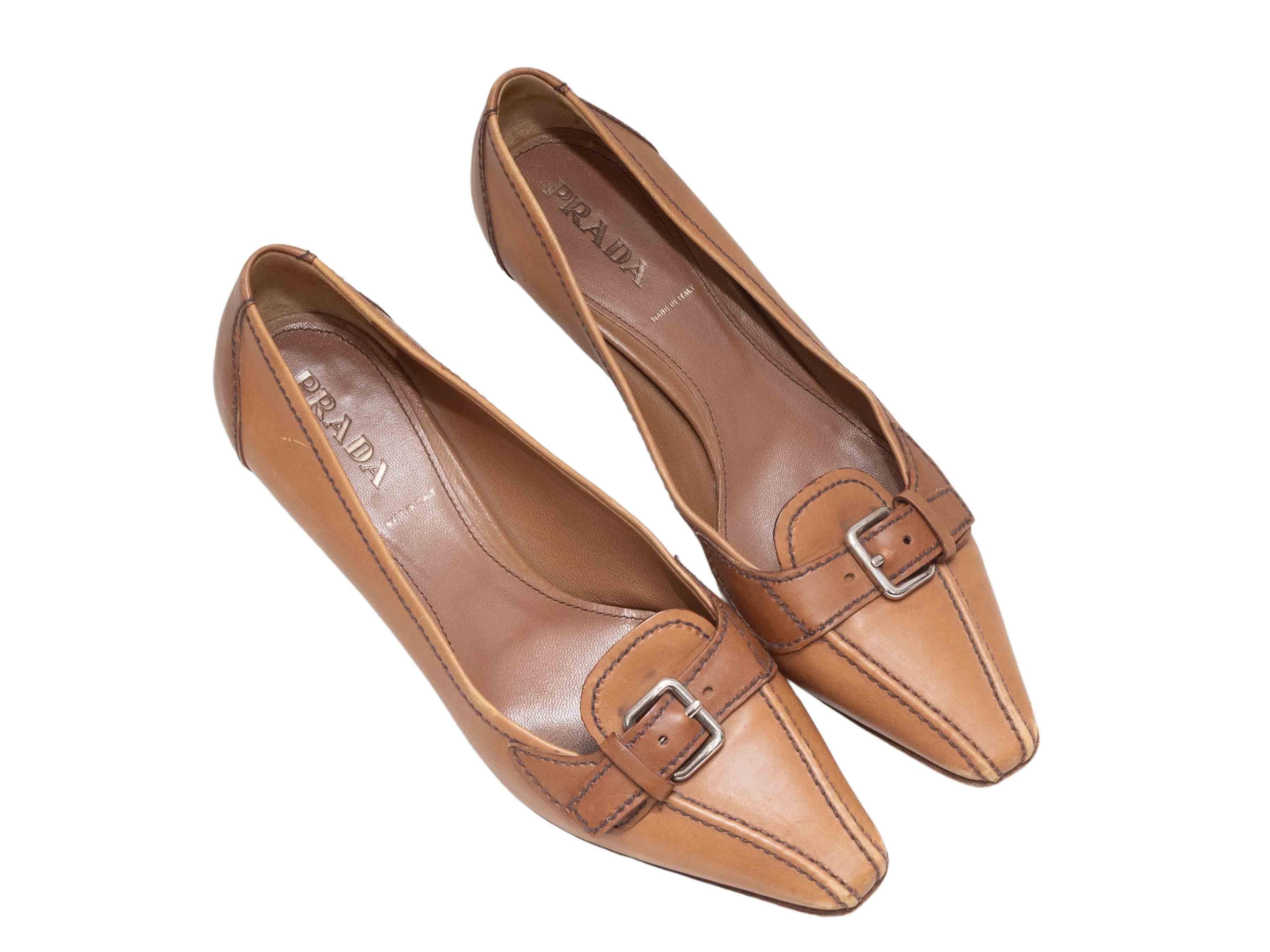 Tan leather pointed-toe pumps by Prada. Buckle accents at tops. Stacked low heels. 1.75