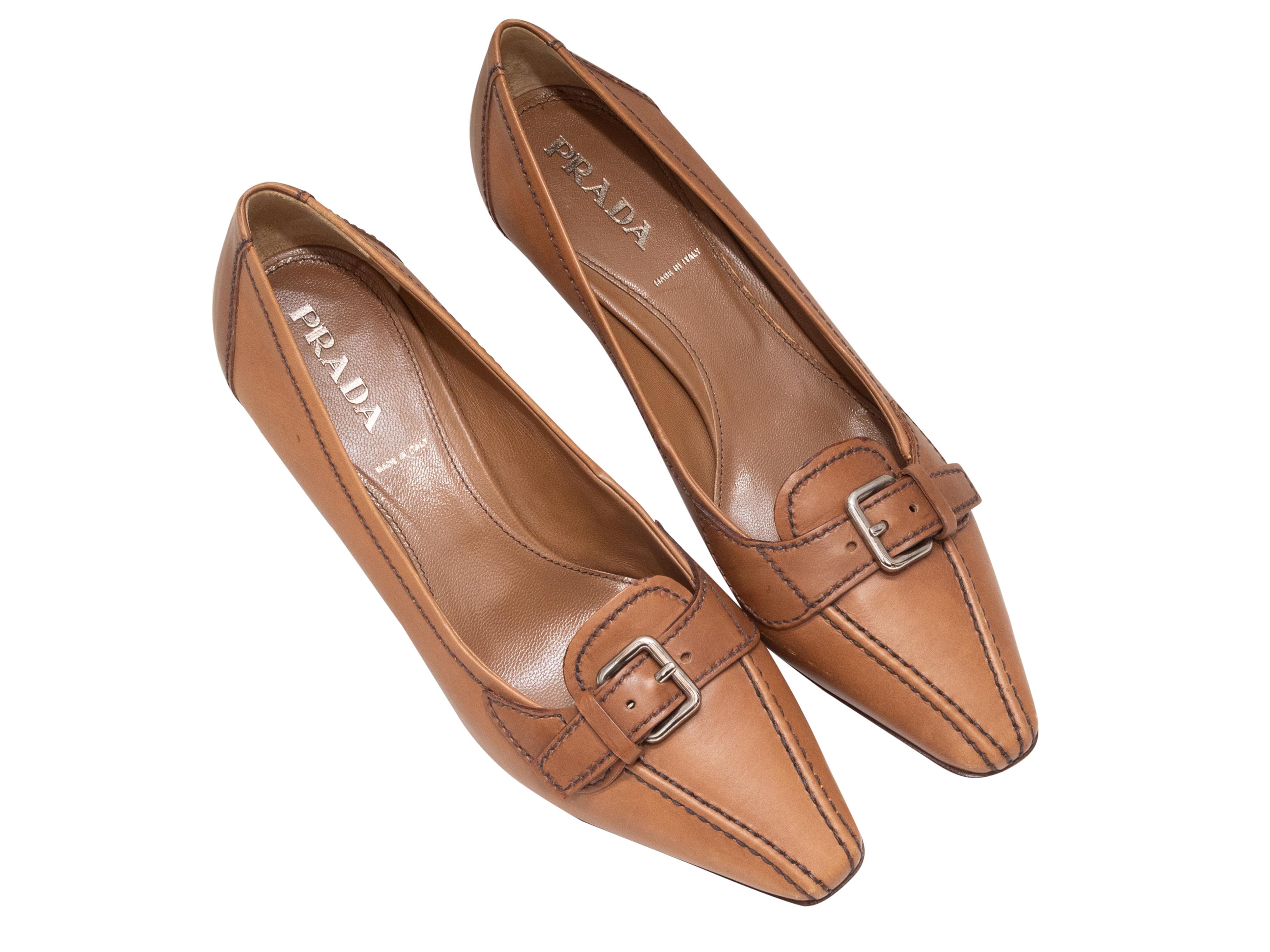 Tan leather pointed-toe heeled loafers by Prada. Silver-tone buckle accents at tops. Stacked heels. 1.75