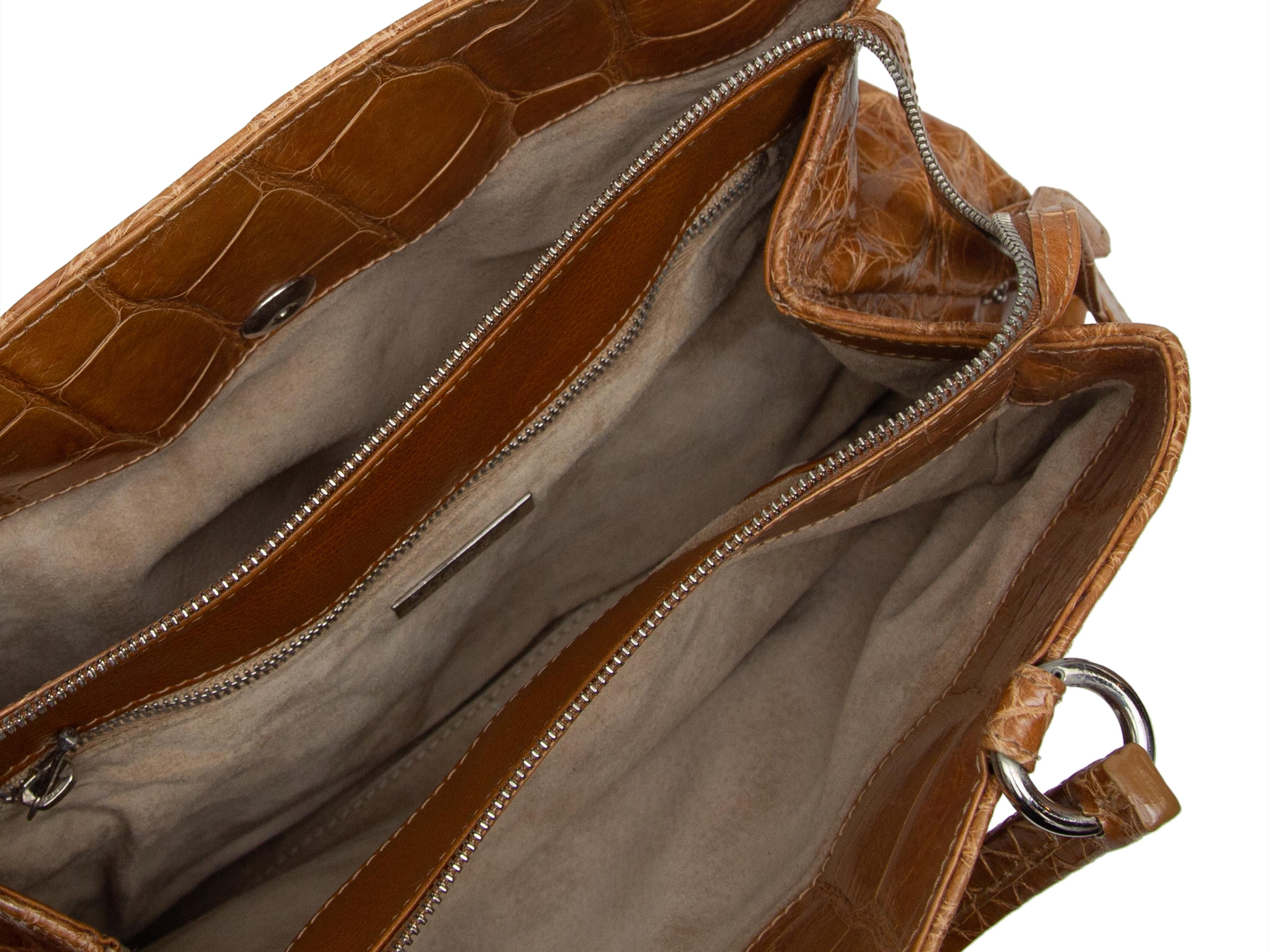 Product details: Tan alligator skin handbag by Suarez. Silver-tone hardware. Dual rolled top handles. Zip closure at top. 12.5