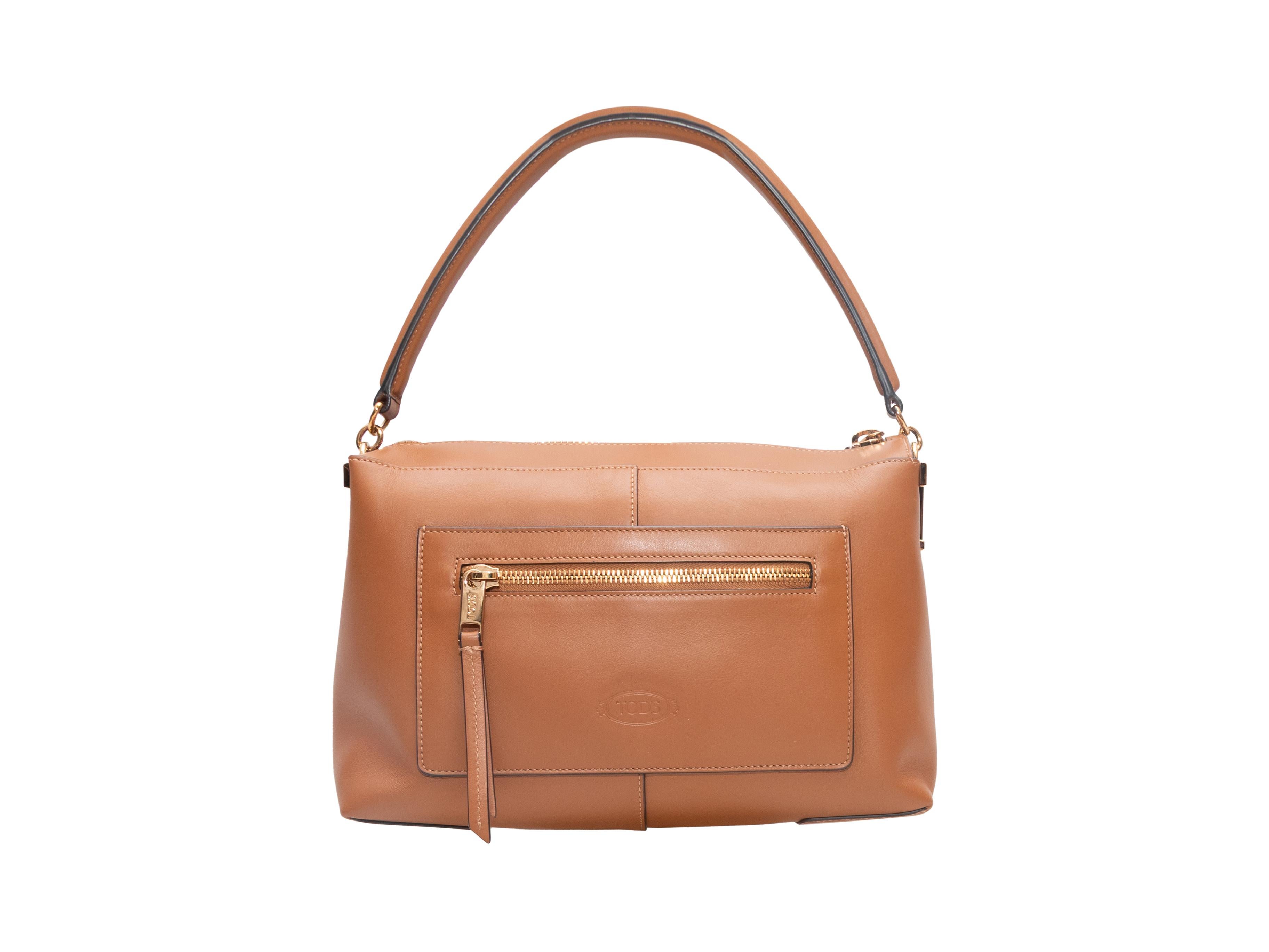 Sac Tod's Tan Small T Case Boston. Le sac Small T Case Boston se compose d'un corps en cuir, de ferrures dorées, d'une seule poche extérieure zippée, d'une seule poignée supérieure, d'une seule bandoulière et d'une fermeture zippée sur le dessus.