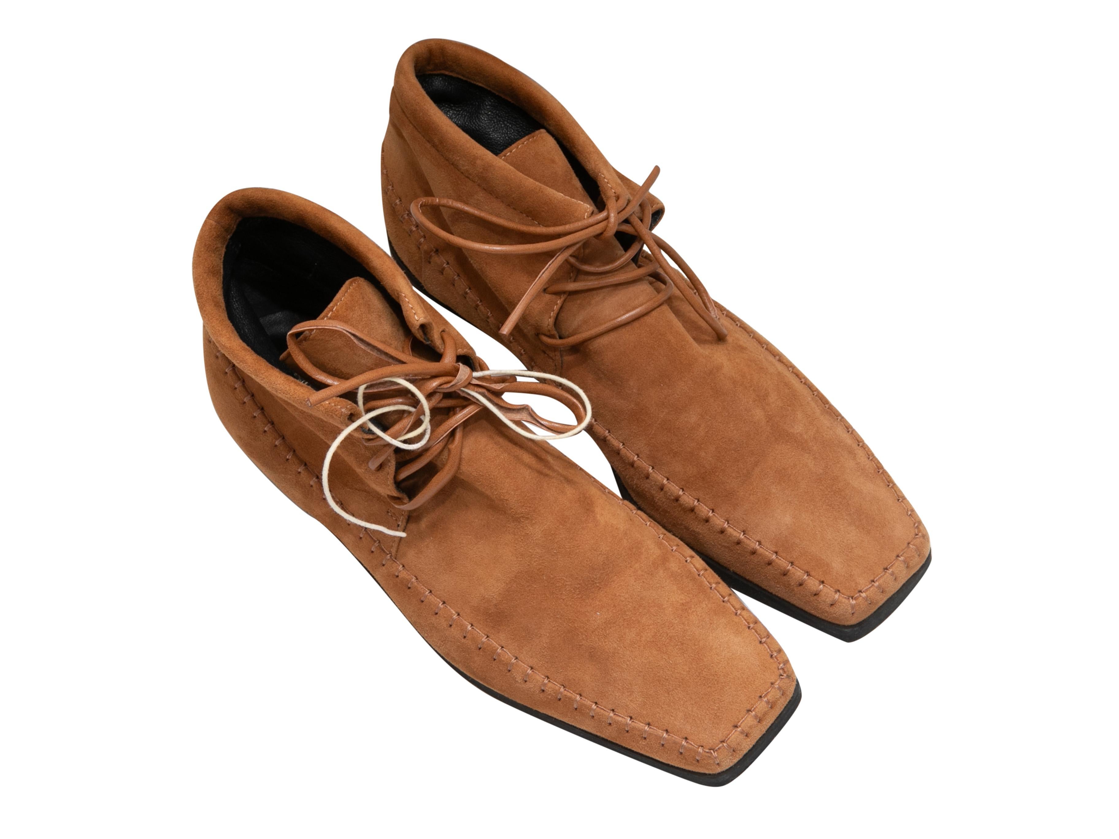 Tan suede high-top square-toe moccasin boots by Toteme. Rubber soles. Lace-up tie closures. 4