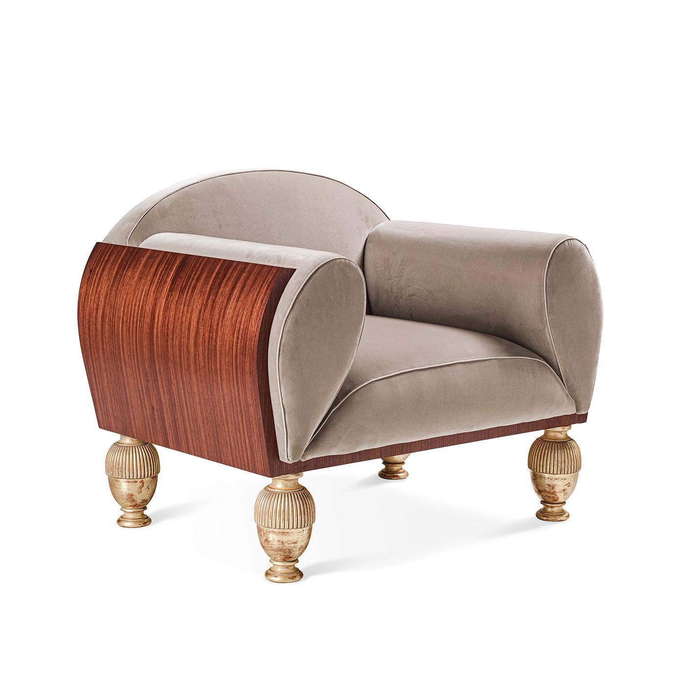 Elegant velvet upholstered armchair, its shape is enclosed in a curved structure plated with Paduk wood. Handcrafted and enriched with the detail of gold leaf finish feet.