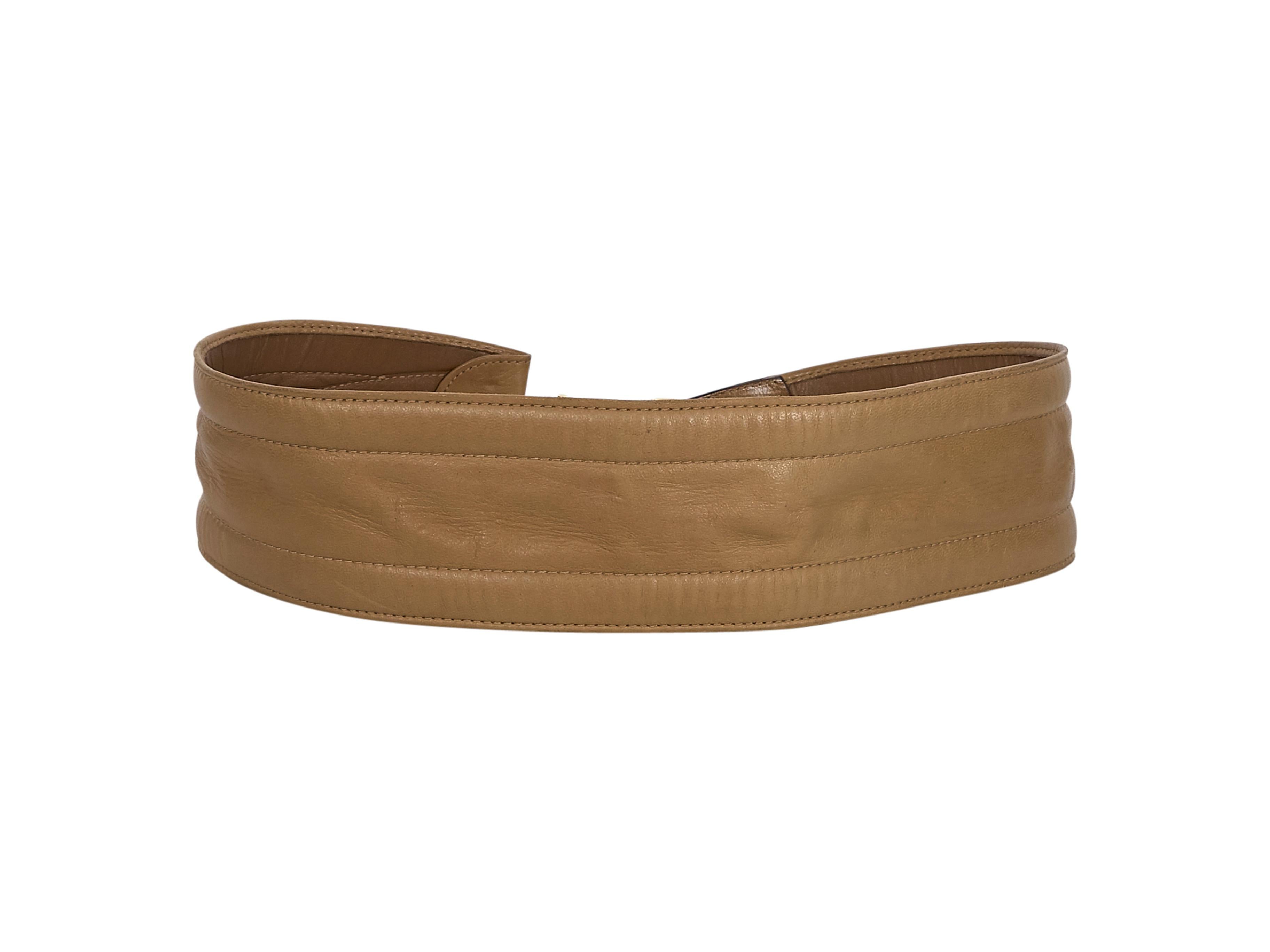Product details:  Vintage tan leather wide belt by Gucci. Adjustable buckle closure. Gold-tone hardware. Style yours with an oversized blouson sleeve dress. 31