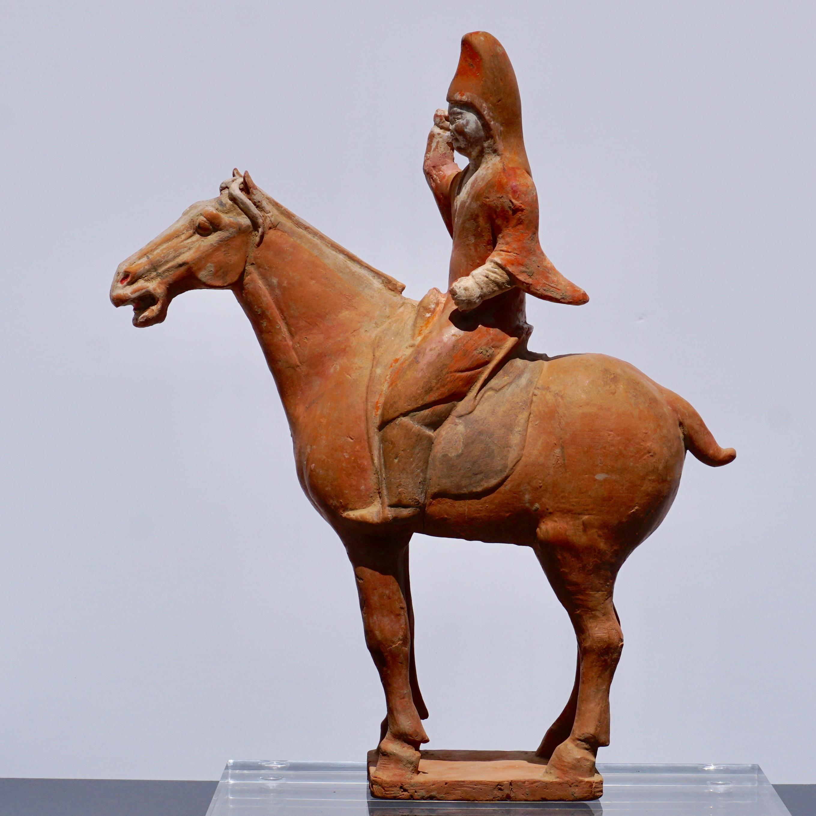 This statuette of a horse with rider was made in terracotta during the Tang dynasty (618-907 A.D.), which is regarded as the Classic age of China. Despite its 1100 or more years of existence, this gorgeous statuette showcases substantial remnants of