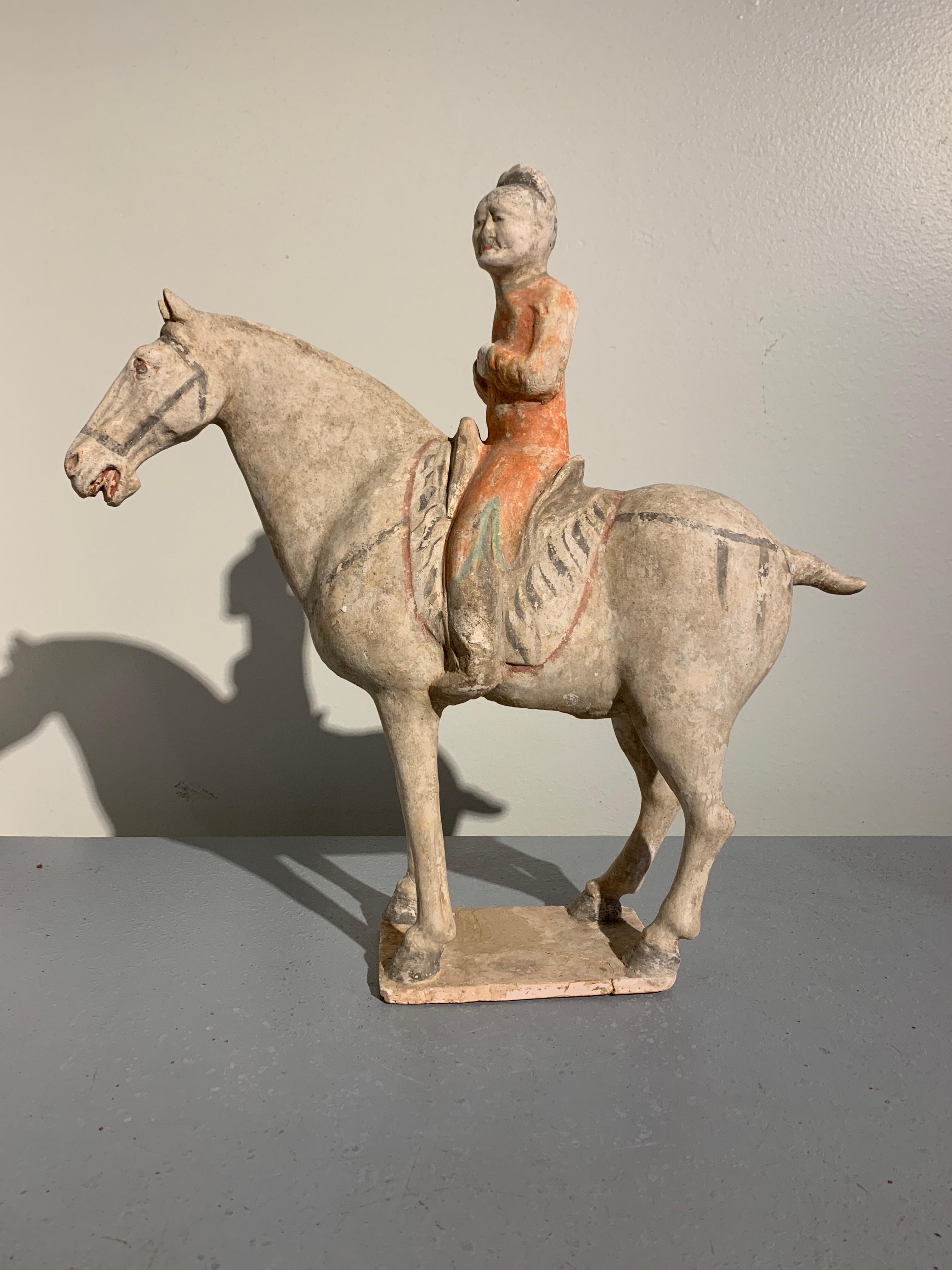 A wonderfully modeled painted pottery figure of horse and rider, Tang Dynasty (618-906 AD), circa 9th century, China. TL tested by Oxford Authentication.

A Classic representation of a Tang Dynasty horse and rider, both figures expressive, with