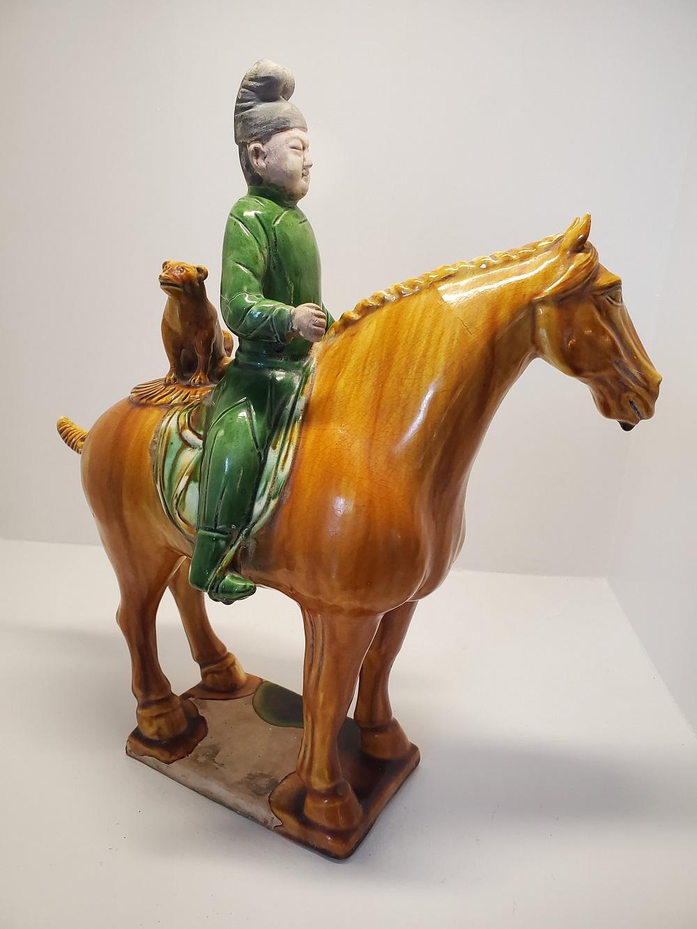 This rare sencai glazed man on a horse is a stunning example of funerary pottery figures used as spirit objects or Mingqi in Chinese burial tombs for millennia. This Tang style horse, rider, and dog appear to be a hunting trio--possibly representing