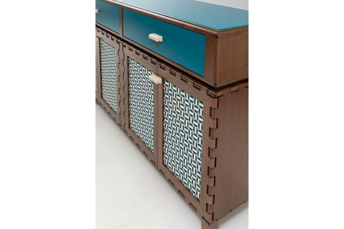 Tangara fabric panels long sideboard by Luis Pons
Dimensions: Width 274.5 x Depth 44 x Height 79 cm
Materials:Fabric, Glass, Walnut, Hand-Crafted

Also available in different colors.

Tangara envisions a new meaning for the wood hinge, a