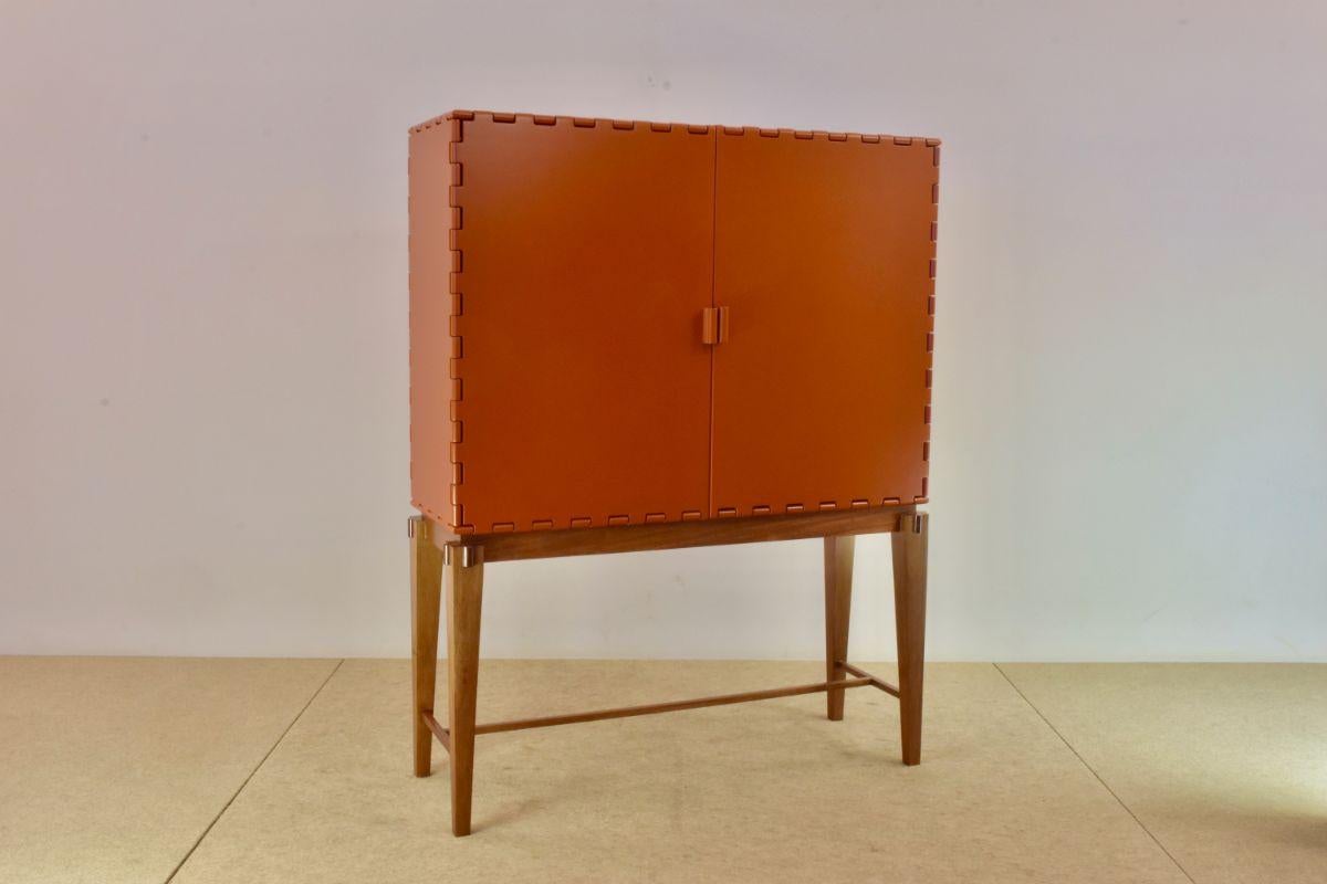 Tangara two door bar pearl orange by Luis Pons.
Dimensions: W 107 x D 36 x H 123 cm.
Materials: wood, hand-crafted.

Also available in different colors,

Tangara envisions a new meaning for the wood hinge, a feature that was previously crafted