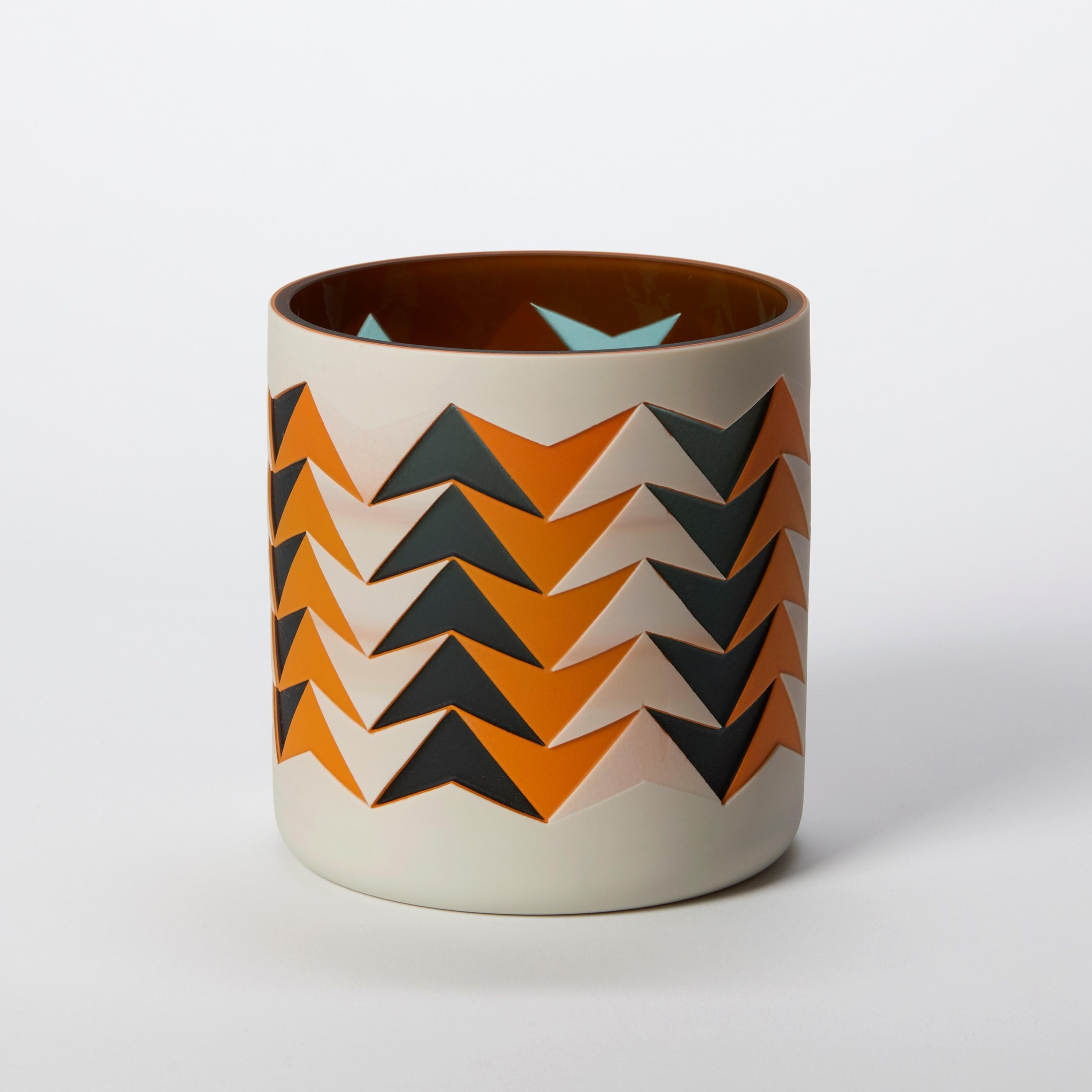 'Tangerine Arrows' è un vaso scultura in vetro unico nel suo genere, realizzato dall'artista britannica Sarah Wiberley. Soffiati a mano da strati di colore, i precisi disegni mostrati sono stati creati mascherando e sabbiando diverse aree, con ogni