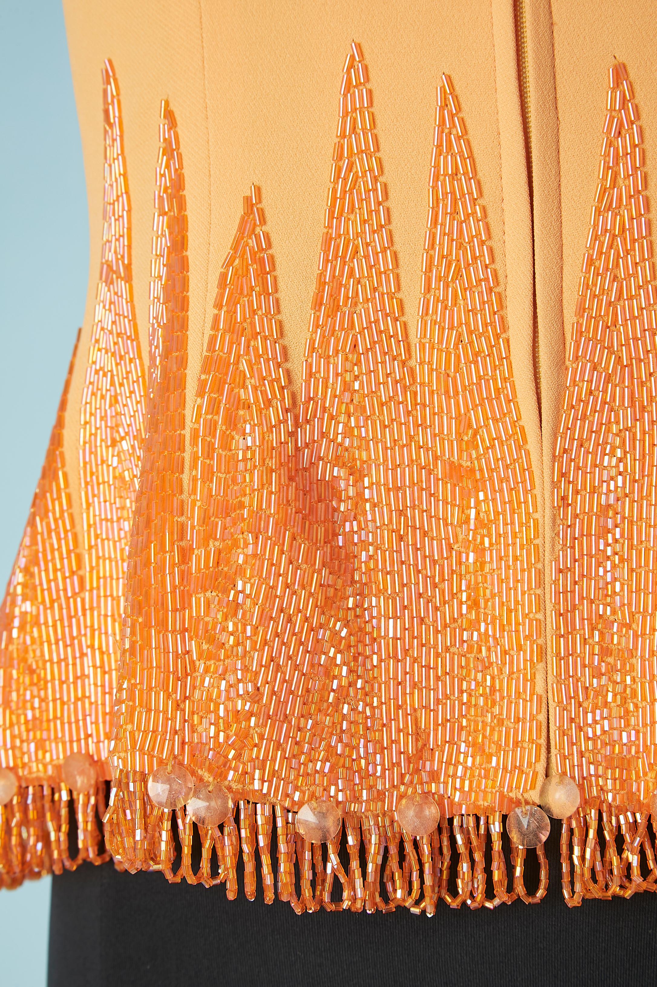 Top de soirée en crêpe mandarine avec fermeture éclair et perles. Franges de perles dans le bord inférieur. Mince pad d'épaule. Composition du tissu : 58% acétate, 42% rayonne (aspect crêpe)  Doublure en soie. 
TAILLE 42 (It) 38 (Fr) 8 (Us)