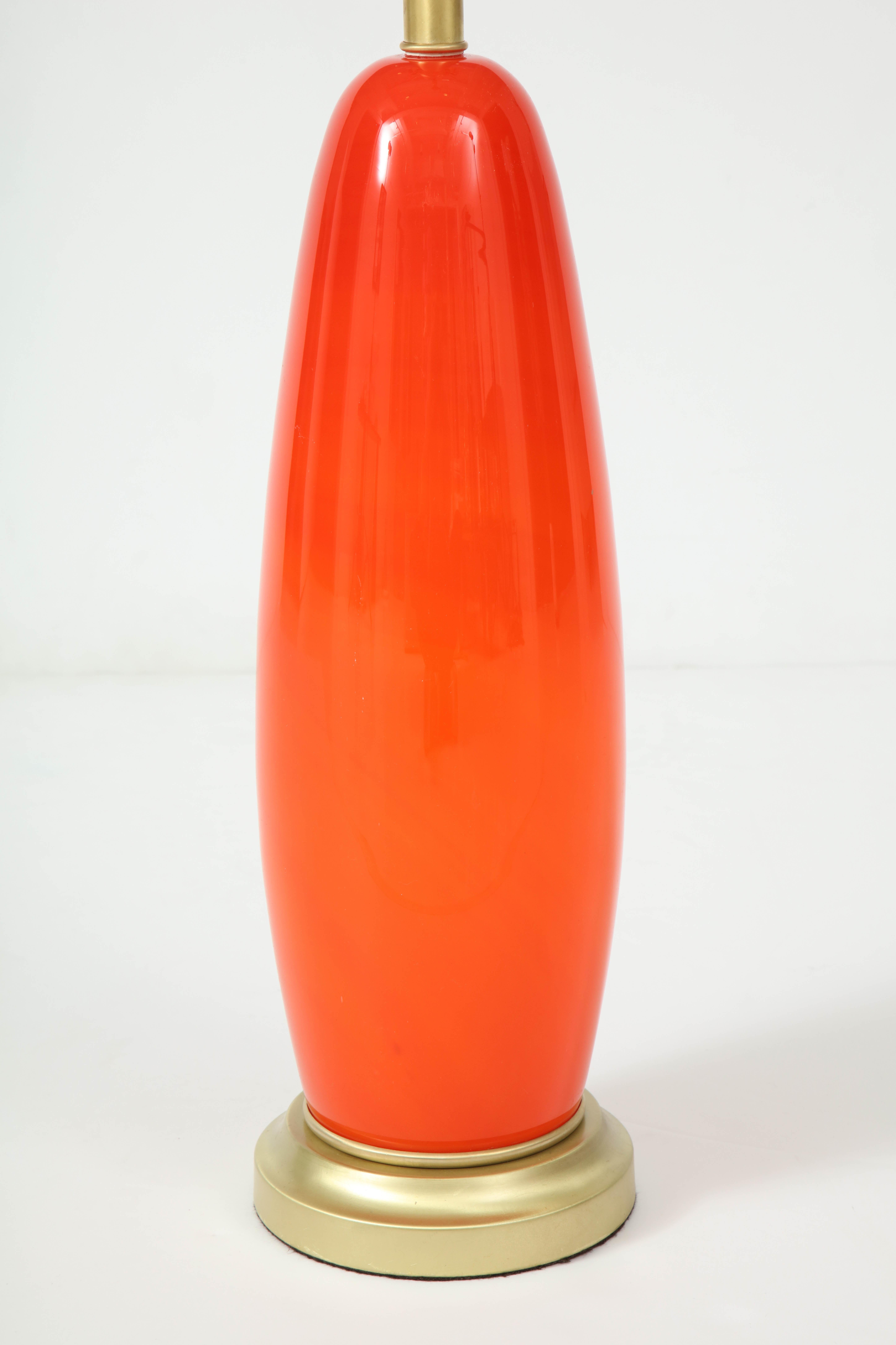 Torpedo shaped Murano glass lamp in a vibrant Tangerine color, with a satin brass base and socket. Rewired for use in the USA.