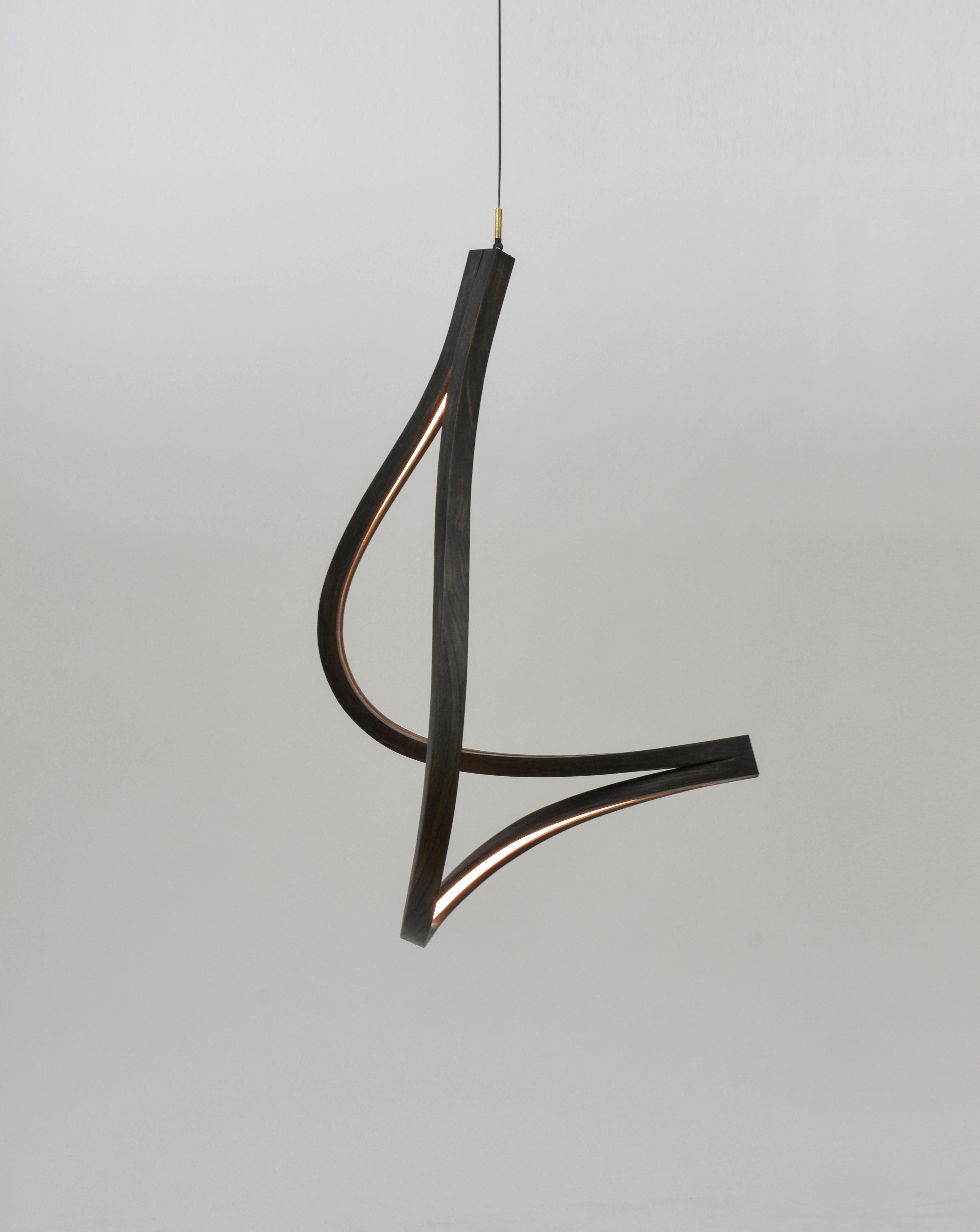 The Tangle is a modular freeform pendant formed from wood, woven diffuser, and high-output dimmable LED. The modular nature allows for a varying number of bent forms (two, three, four, etc.) to be joined together at various points along the fixture