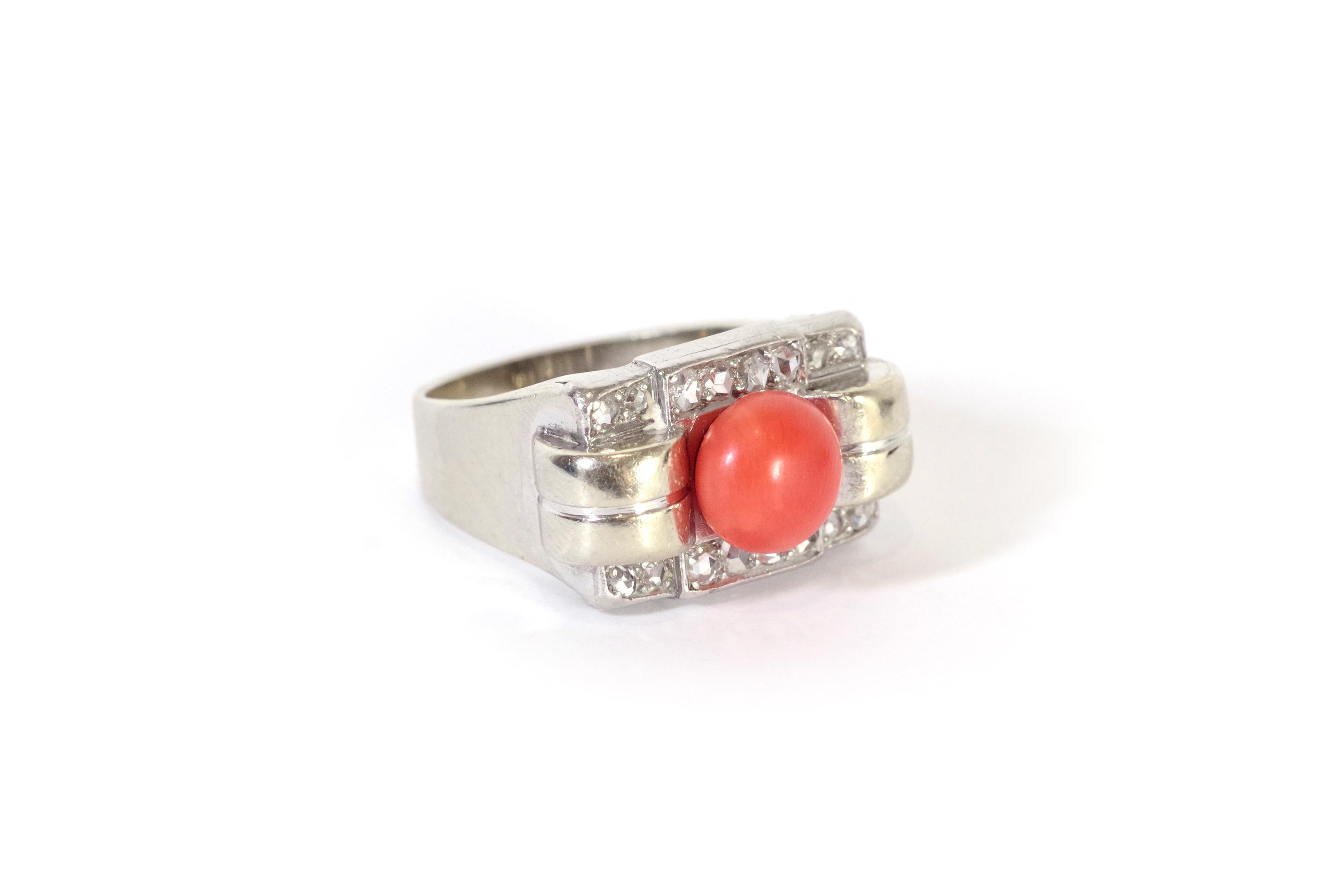 Tank coral diamond ring in 18 karat white gold and platinum. The ring is centred on an orange coral pearl surrounded by two rolls of gold and framed by two lines of eight rose-cut diamonds (sixteen in all). The jewellery features the geometric lines