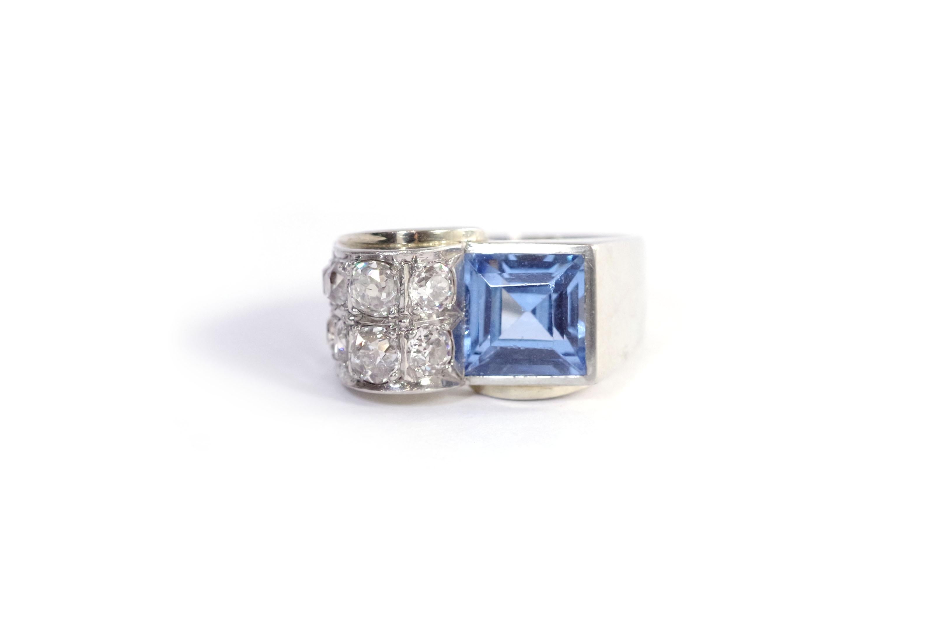 Tank ring with diamonds in 18-karat white gold and platinum. Tank ring set with a synthetic blue spinel of square cut. The spinel faces two lines of four old-cut diamonds (eight diamonds in total) set on a raised roll. The ring has harmonious