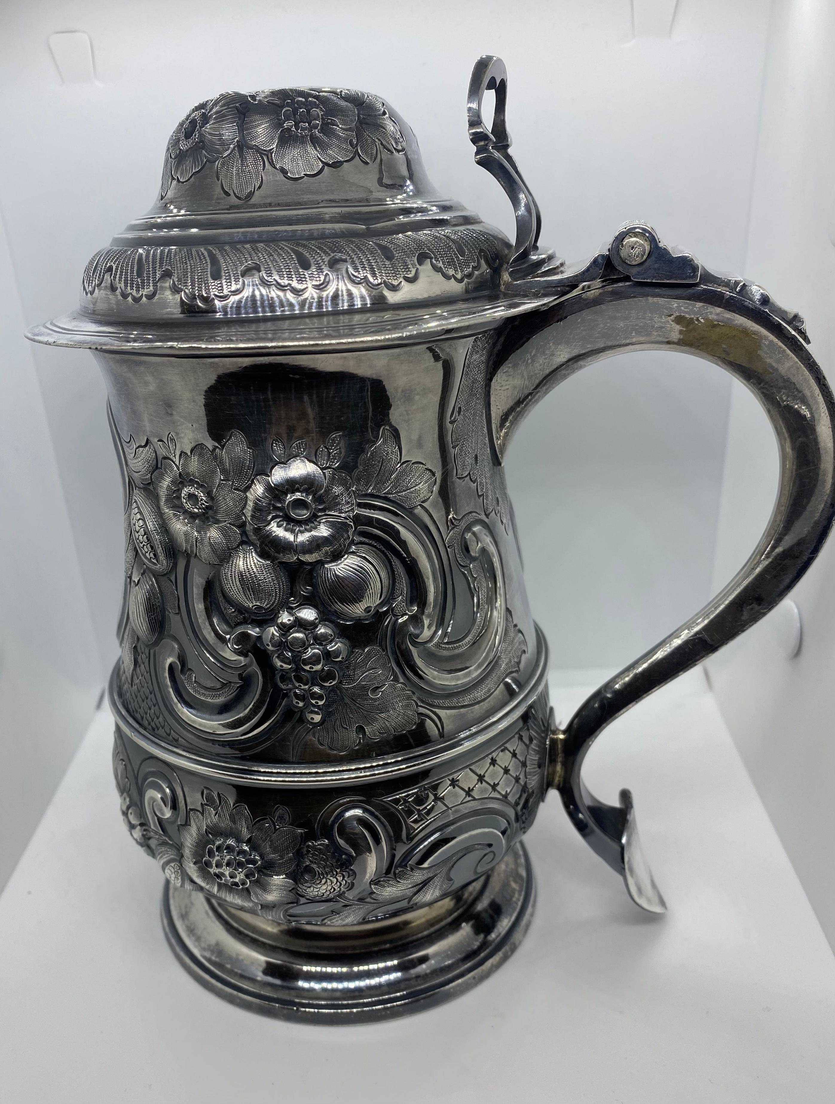 A beautiful GeorgeIII English silver Tankard made in London 1818,
Tankard is embellished with later chased stemmed floral and foliate decoration,hand-embossed with gilt interior.The cover is encircled with two bands of chased floral and foliage