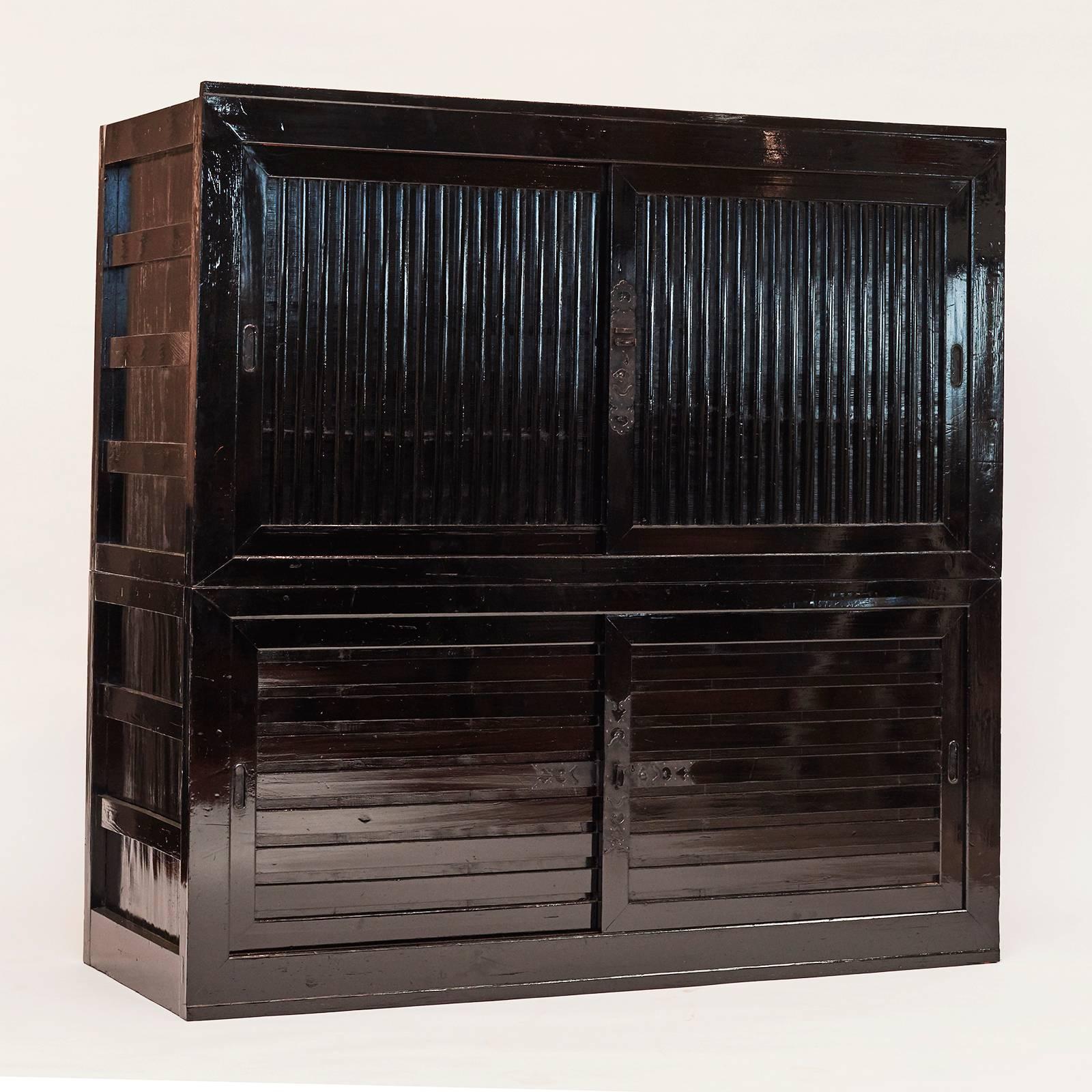 Tansu cabinet, black lacquer. Japan, The Meiji era (1868-1912) the cabinet is in 2 parts. Each part with sliding doors. A simple and stylish cabinet.