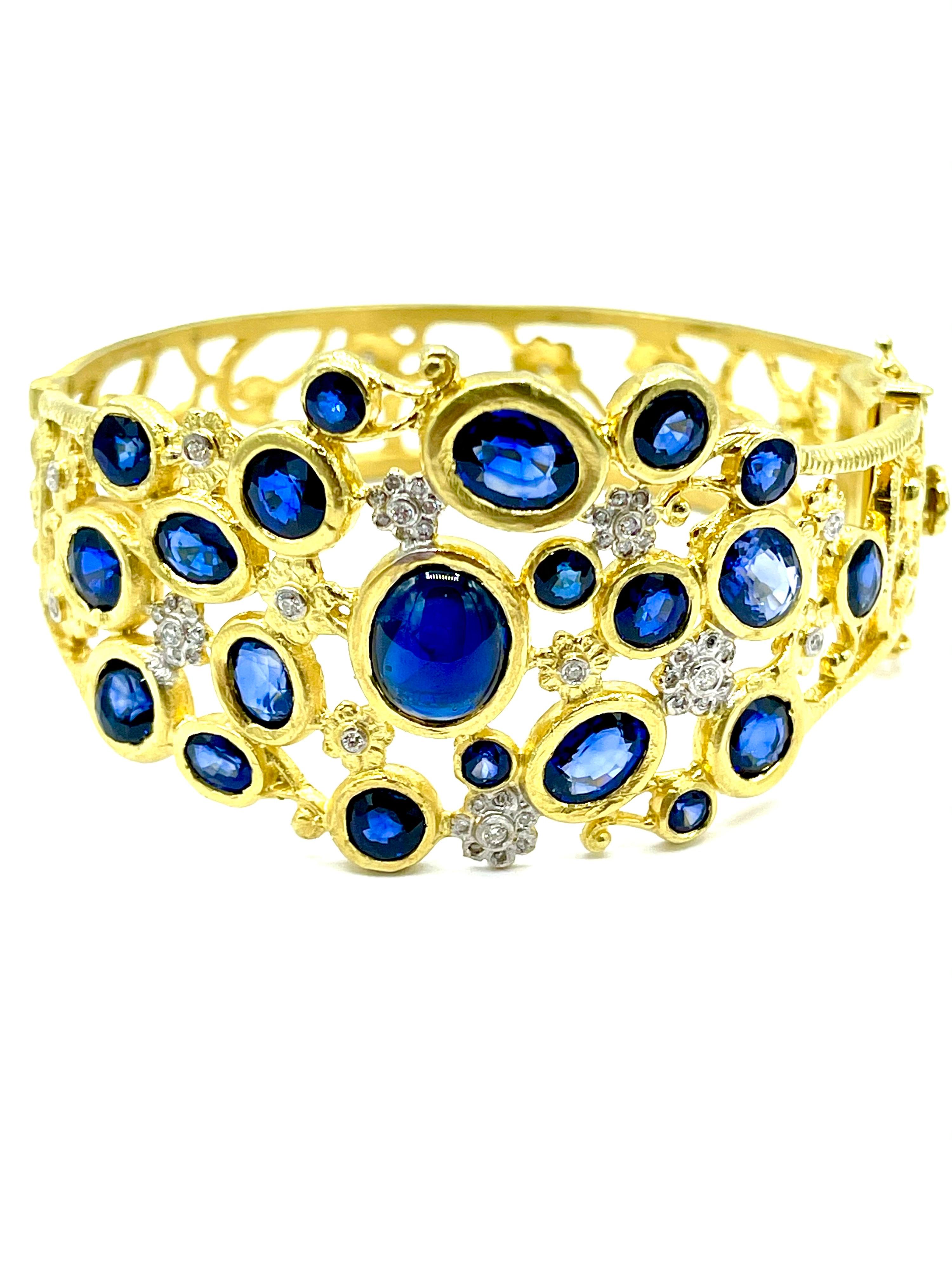 An absolutely stunning Tanya Farah Sapphire and Diamond bangle bracelet in 18K yellow gold.  The top portion of the bracelet has 21 bezel set Sapphires, one large cabochon, and 20 faceted round and oval shapes for a total of 29.70 carats.  The round