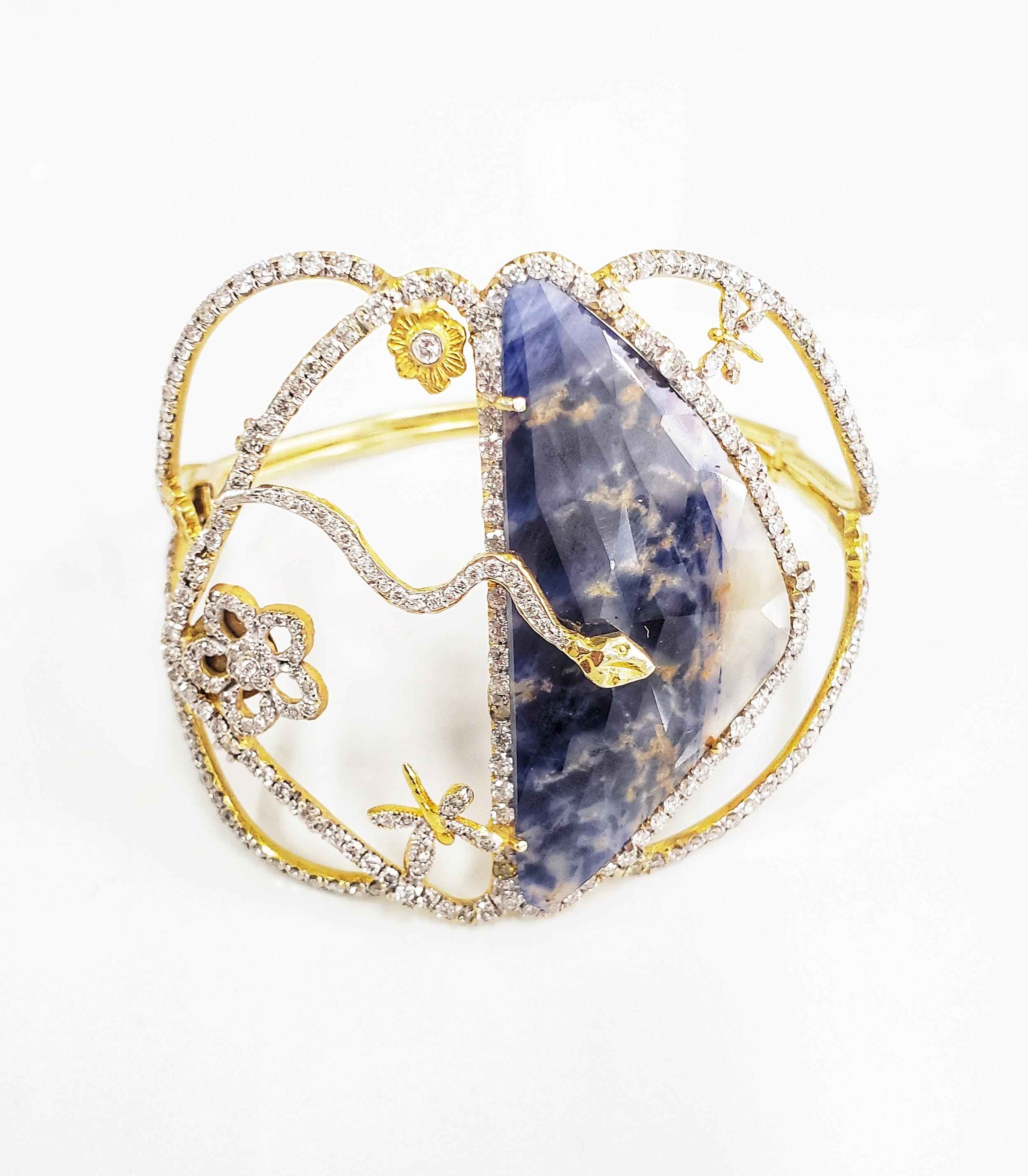 Tanya Farah cuff boasts exquisite motifs from the Garden of Eden.  One-of-a-kind natural blue sapphire is showcased in center and surrounded by champagne and white diamond halos.  Beautiful diamond animals and flowers grace the garden of this large