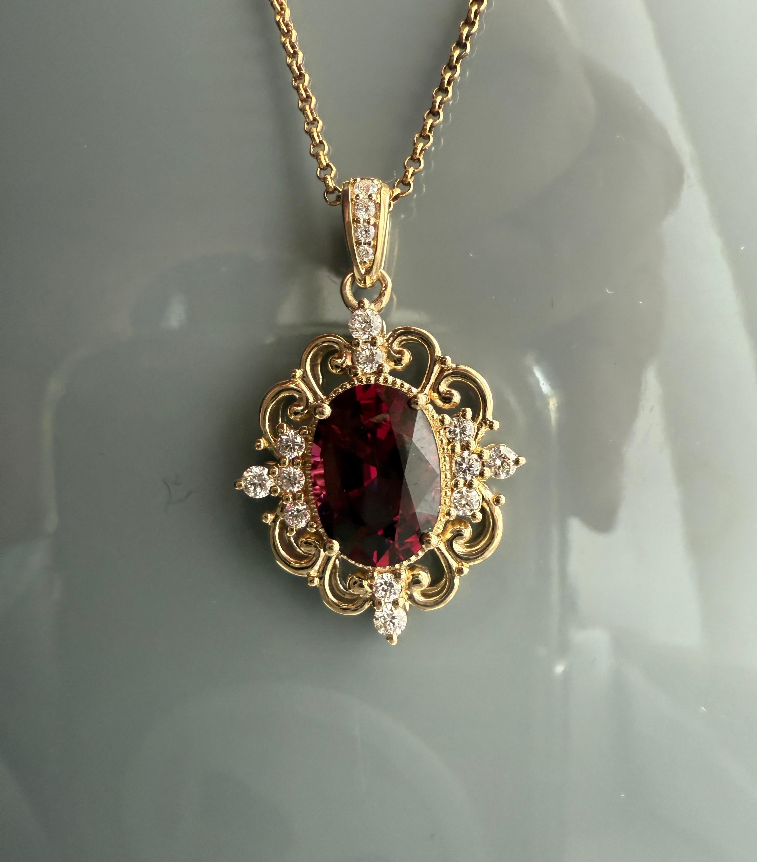 Le pendentif en or jaune 14 carats dégage une élégance vintage avec de subtiles influences Art of Vintage, aboutissant à une pièce qui allie harmonieusement le charme d'antan et le savoir-faire contemporain. Sa pièce maîtresse, un grenat ovale d'un