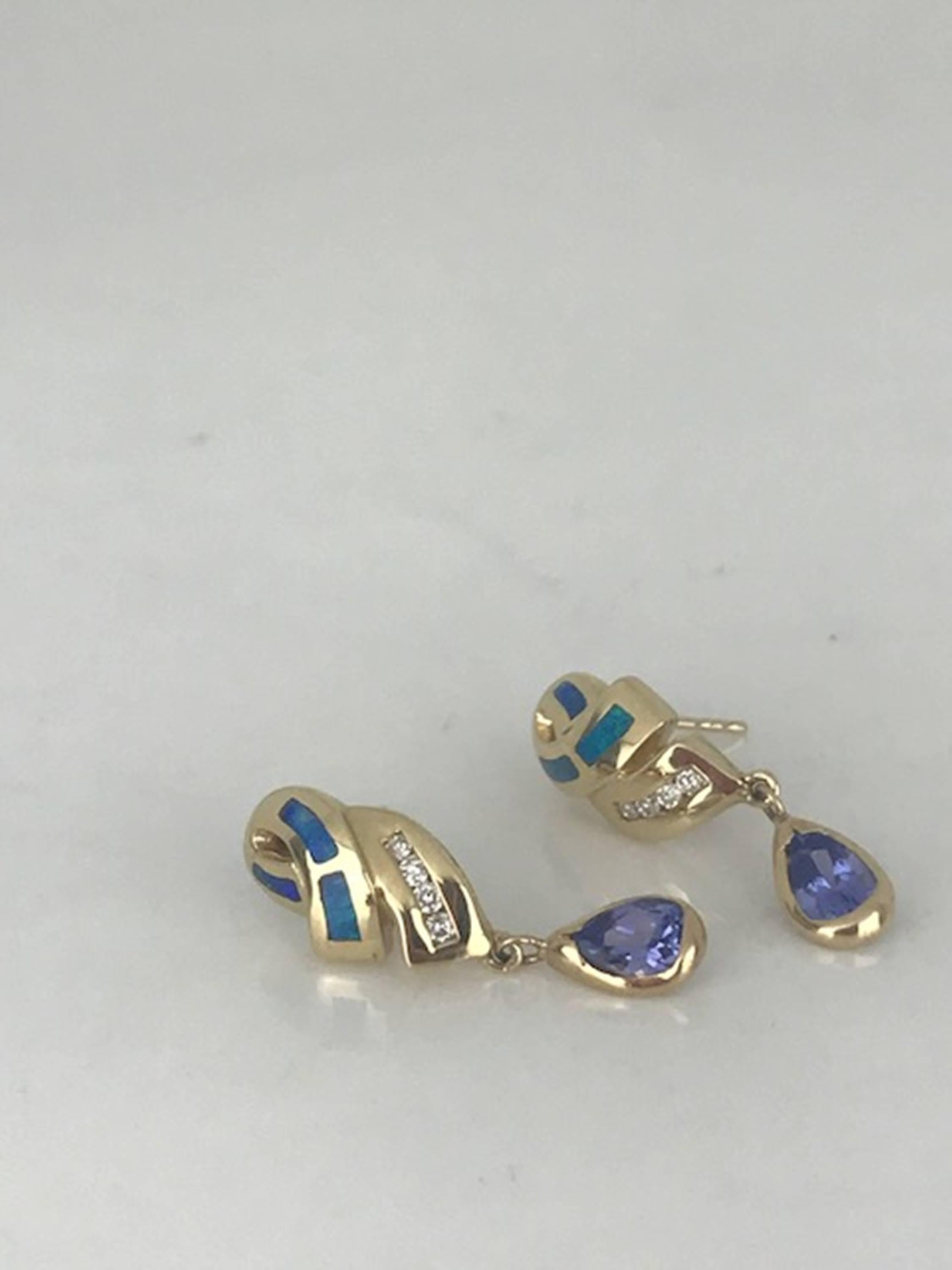 Stunning, tanzanite diamond earrings dangling with these 14 karat yellow gold drops. 
Tanzanites each measure 6.38 x 4.9 x 3.41 millimeters and are encased is a bezel. Circa 1985
The (8) round diamonds are channel set and have a total weight of