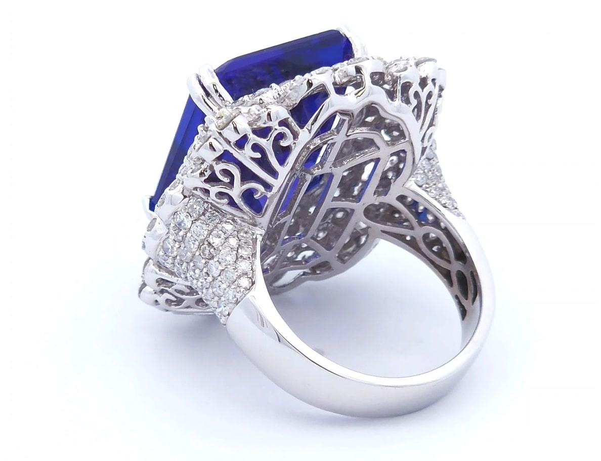 Luxury, at the right price.

This unique ring has a 23.64 carat total weight. The center stone is a tanzanite emerald cut weighing 19.89 carats. Surrounding the tanzanite are 3.75 carats of round cut diamonds set in 18K white gold.

This ring is set