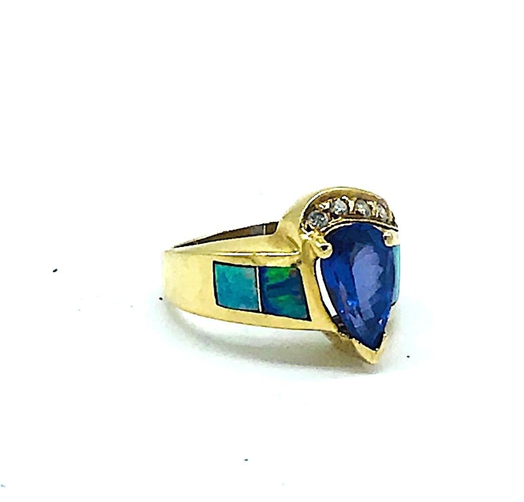 Tanzanite Ring,  Australian Opal Inlay and Diamond, 14 karat. Brilliant center pearl, tanzanite measuring 10.60 x 7.44 x 6 mm having a total weight of estimated 2.96 carats. Inlay, Australian opals flank either side of the ring.  (5) round diamonds