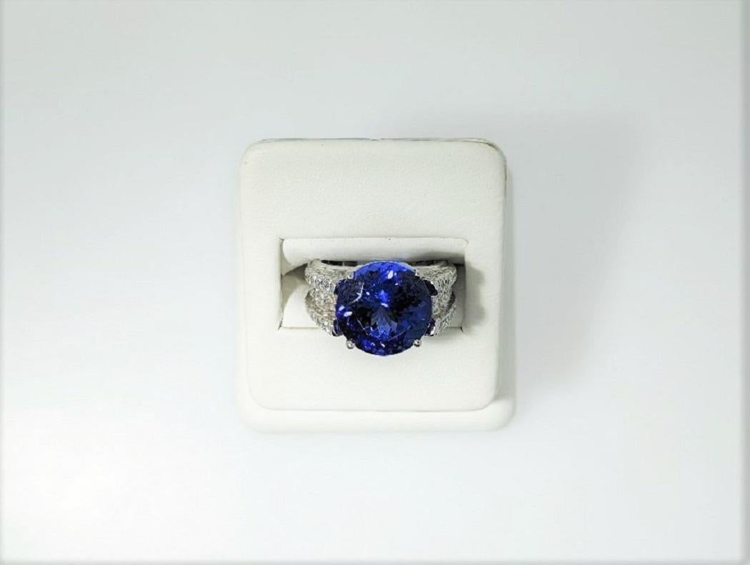 Born in Tanzania Africa, this round gemstone of 9.17 carats radiates various hues of deep blue with some purple accents.  It is set in an 18K white gold mounting weighing 8 grams contains 104 diamonds that weigh 1.91 cts.  All of the diamonds in