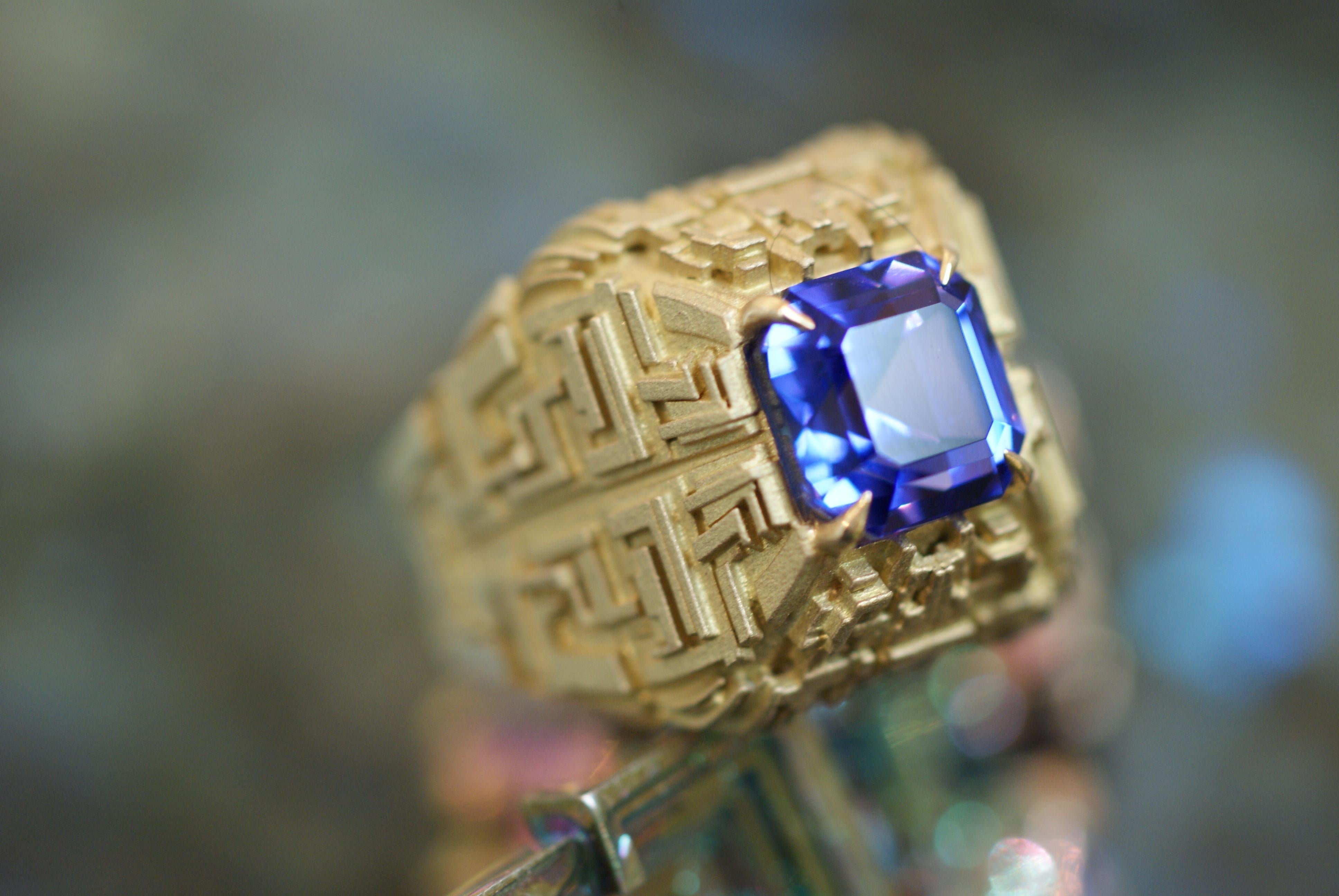 Designed as an Asscher-cut tanzanite, within an 18K gold Mayan inspired setting. The design was inspired by the geometry of bismuth crystals, which evoke Mayan landscapes on an alien planet.

This ring is one of a kind.

Description:
Gem details: