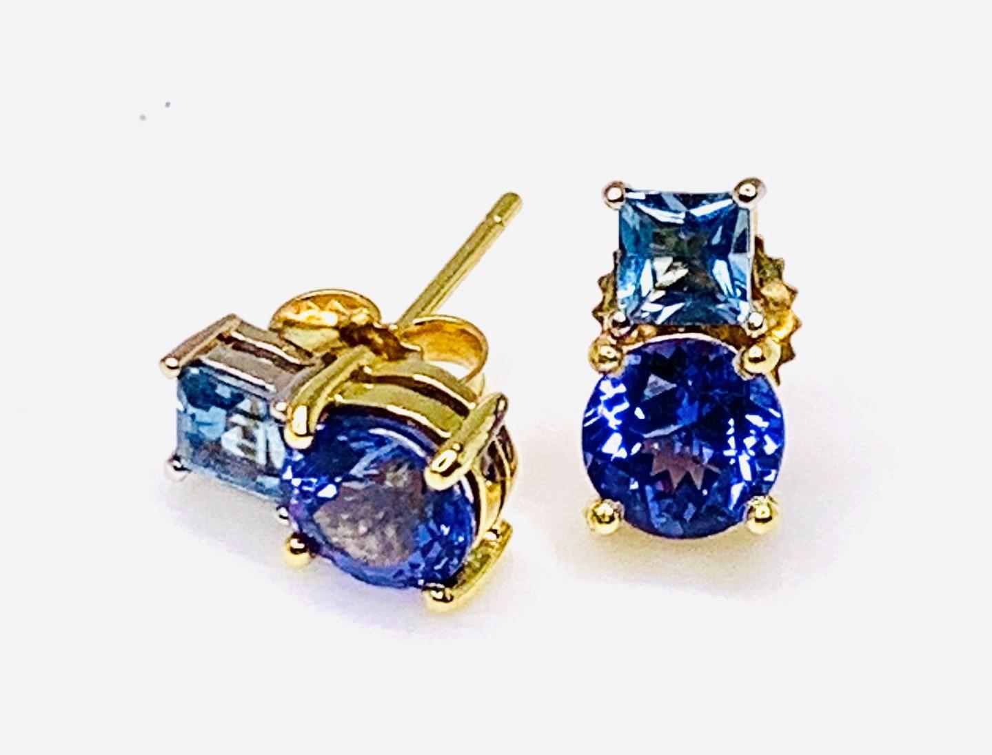 These post earrings convey chic sophistication with the gorgeous combination of tanzanites and fancy shaped aquamarines! The tanzanites have bright, rich color and look beautiful paired with square, crystalline aquamarine. Handmade in 18 yellow and