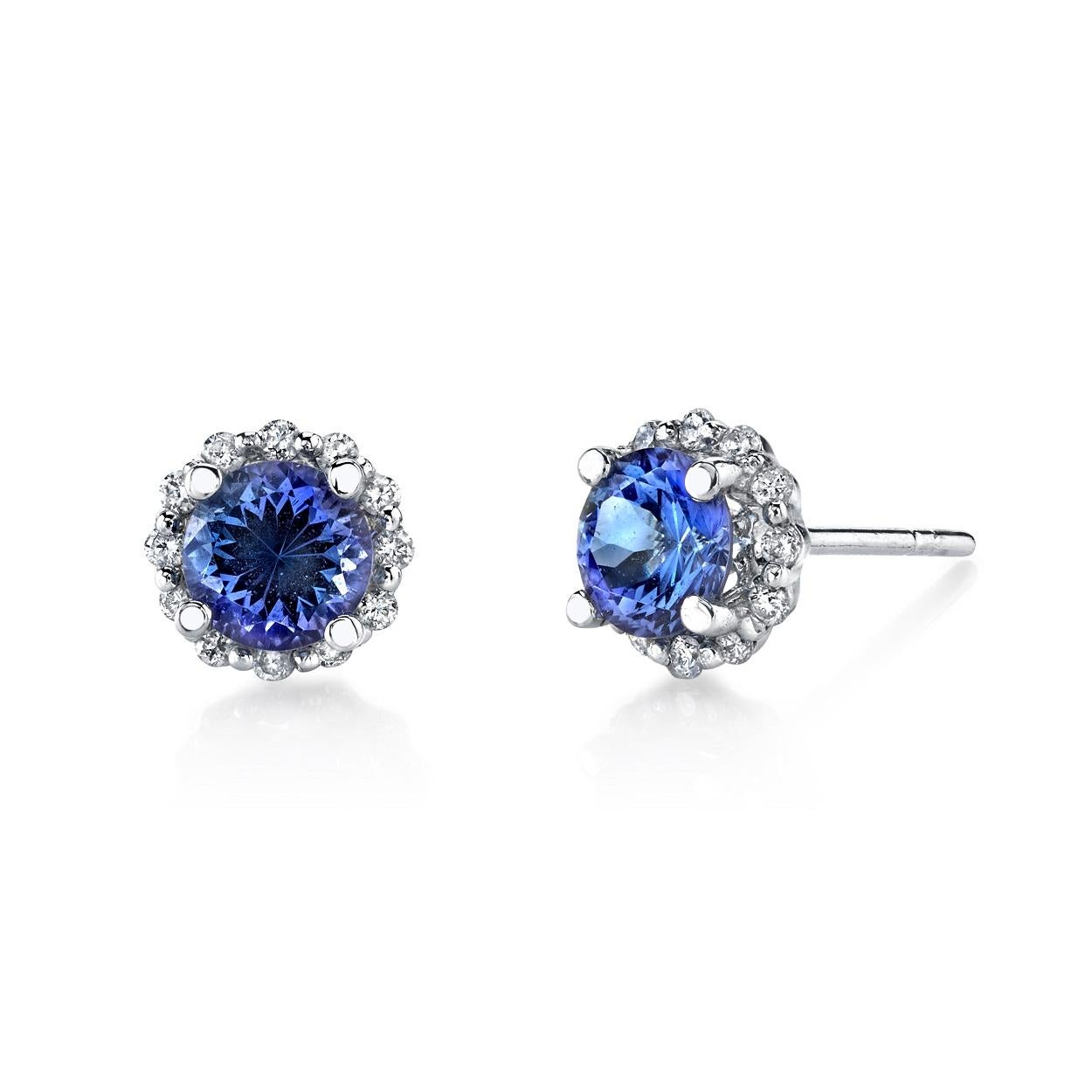 This classic pair of stud earrings features brilliant faceted tanzanite rounds weighing 1.70 carat total. Surrounded by a halo of sparkling diamonds and set in 18k white gold for a refined and timeless look, these jewels are perfect for both day and