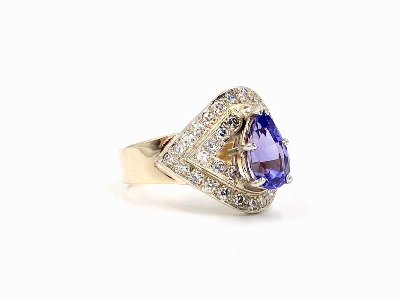 Circa 1960's, this Art Deco Style revival 14 karat two tone gold ring features a pear shape Tanzanite and single cut white diamonds. Diamonds are set in white gold with quality of approximately H color, SI1 clarity. Tanzanite is approximately 1.30