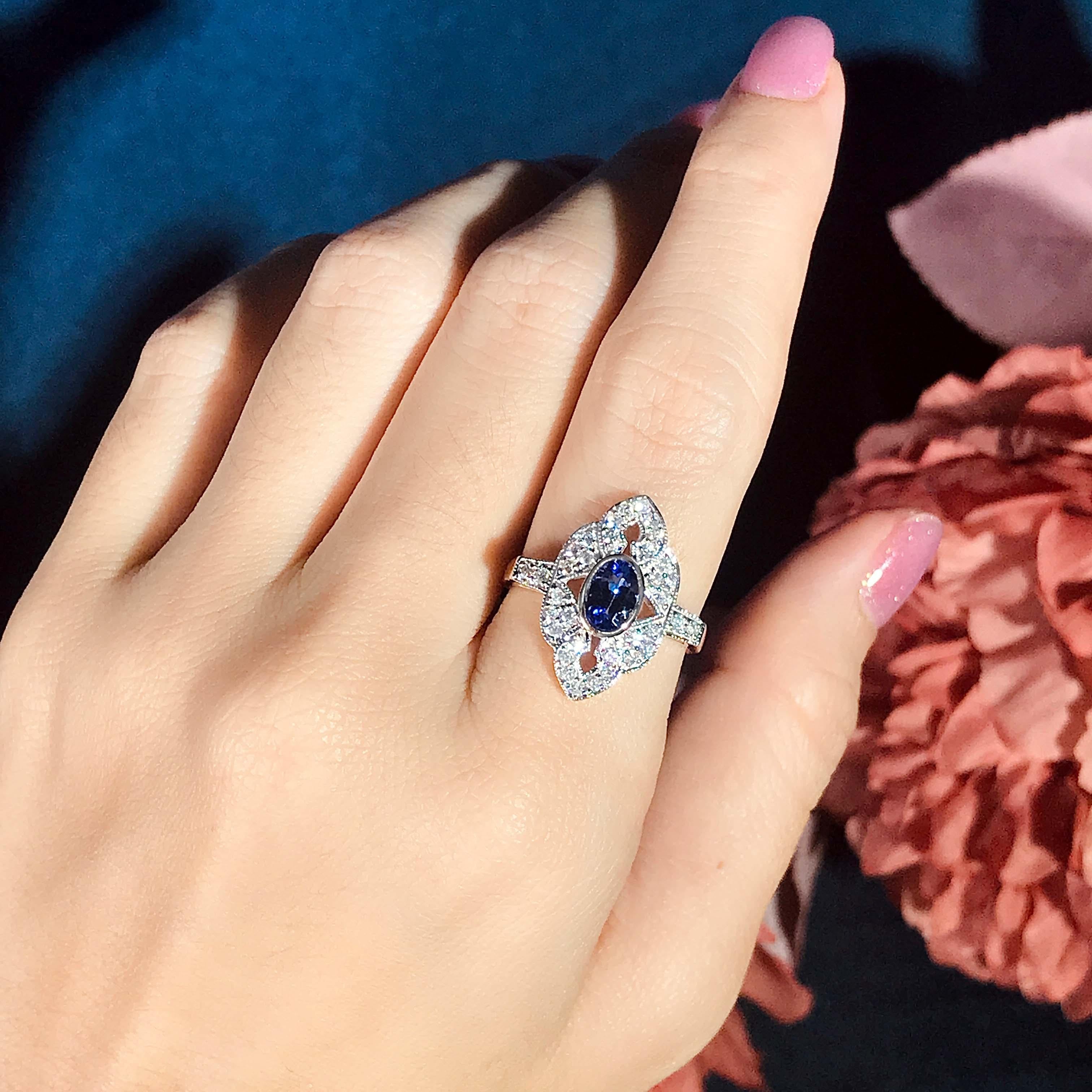 A two-tone gold vintage inspired Tanzanite and Diamond Engagement Ring. This gorgeous antique style elongated ring features charming blue tanzanite at approx. 1.10 carat and diamonds accent. This ring features milgrain edges on the metal. A jewelry