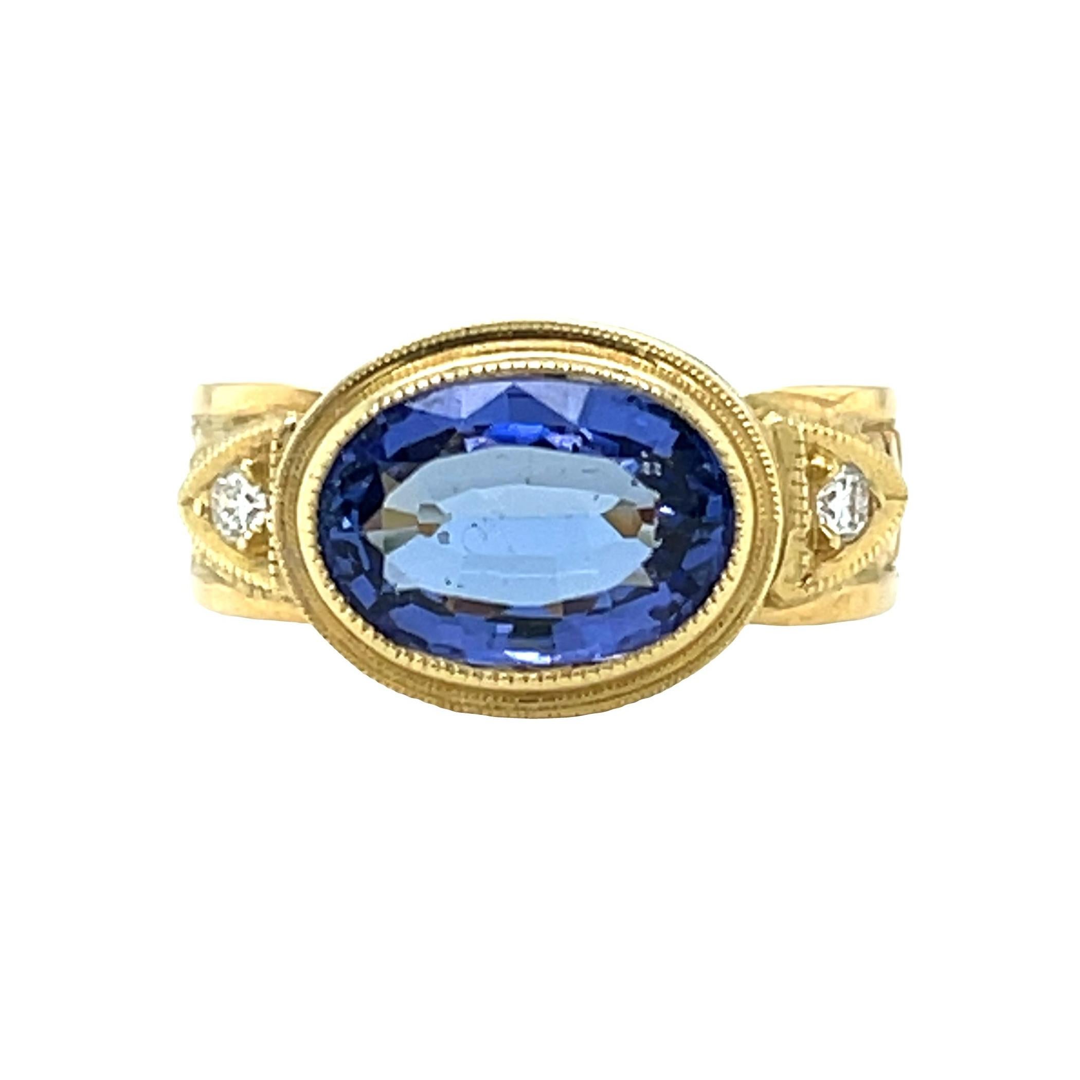 This handmade 18k yellow gold ring features a lovely periwinkle color tanzanite. It has been set 