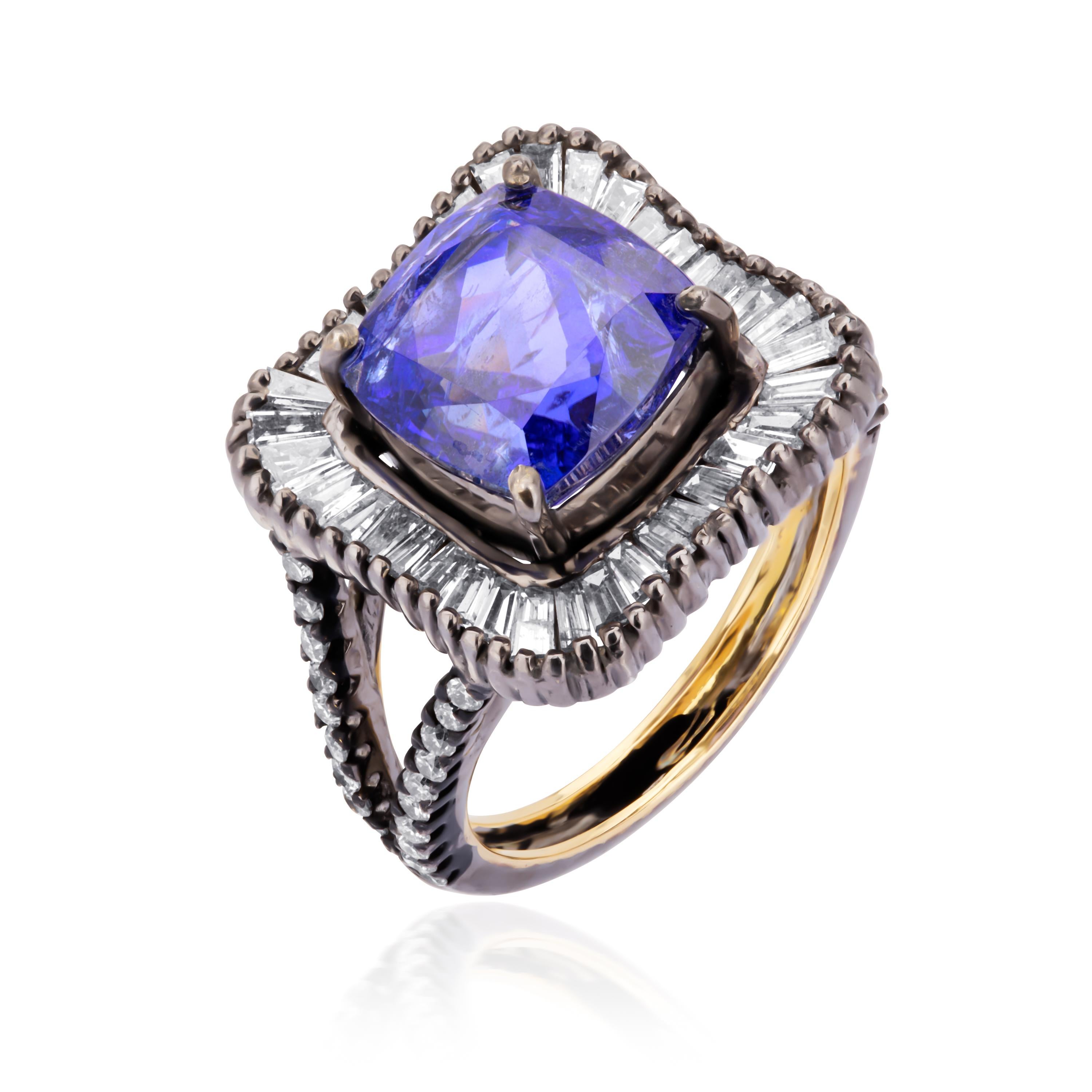 A classic ring that is bound to steal your heart. This lovely Victorian jewel is highlighted with a rich cushion cut tanzanite, weighing 5.16 Cts, framed all around in a sparkling pool of baguette diamonds. The center design is accompanied with an