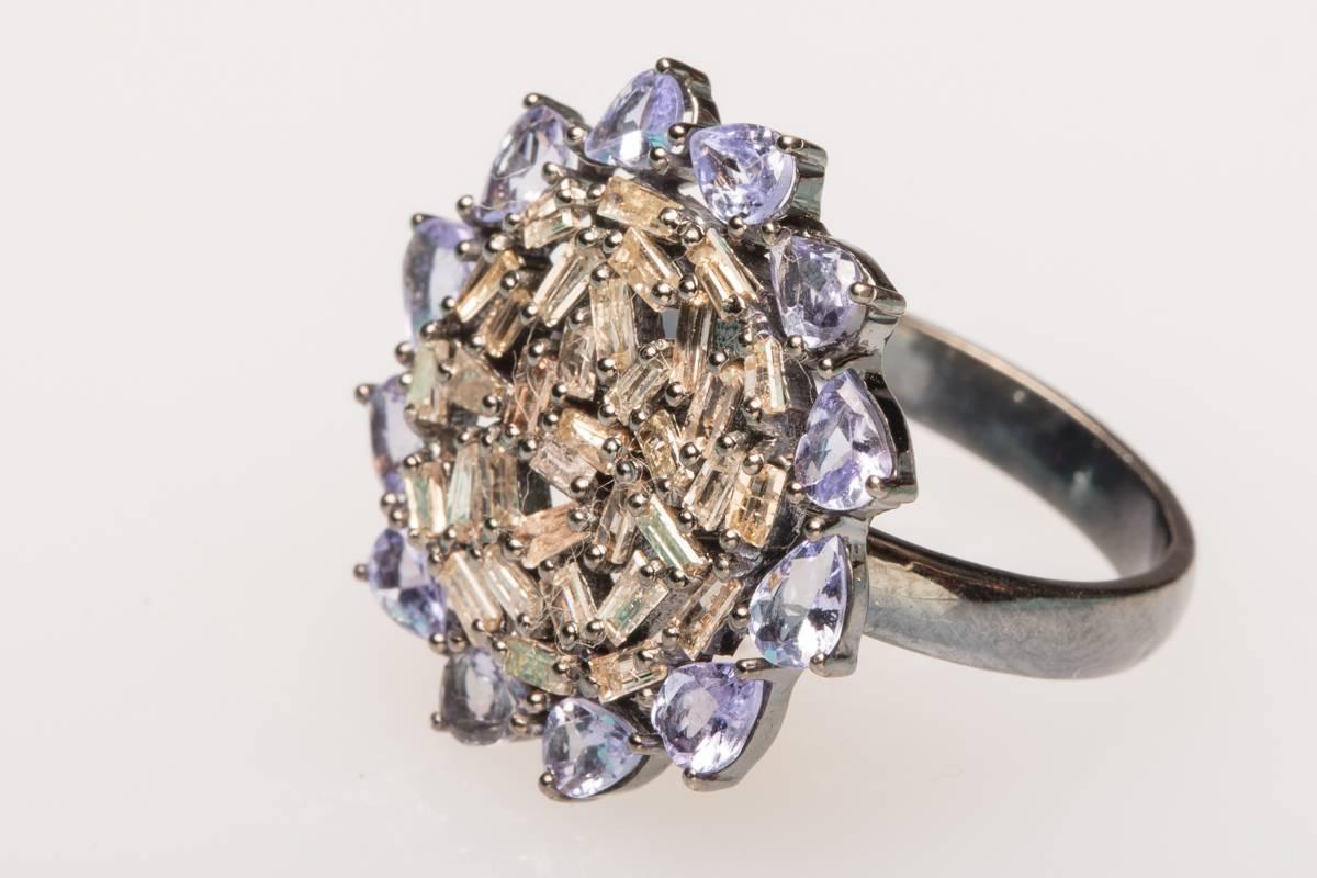 A cluster of baguette diamonds surrounded by pear-shaped, faceted diamonds set in an oxidized sterling silver.  Carat weight of diamonds is .97, tanzanite is 1.47 carats.  Ring size is a 7.  Very unusual cuts and setting.