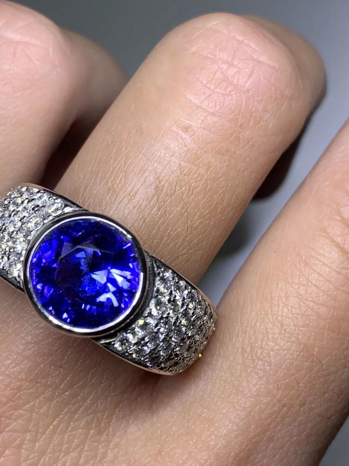 Fai una dichiarazione d'amore con questo splendido anello di fidanzamento solitario con tanzanite e diamanti da 6,61 carati. Realizzato in oro bianco 18 carati, questo gioiello artigianale vanta una fascia larga e una bellissima tanzanite a forma
