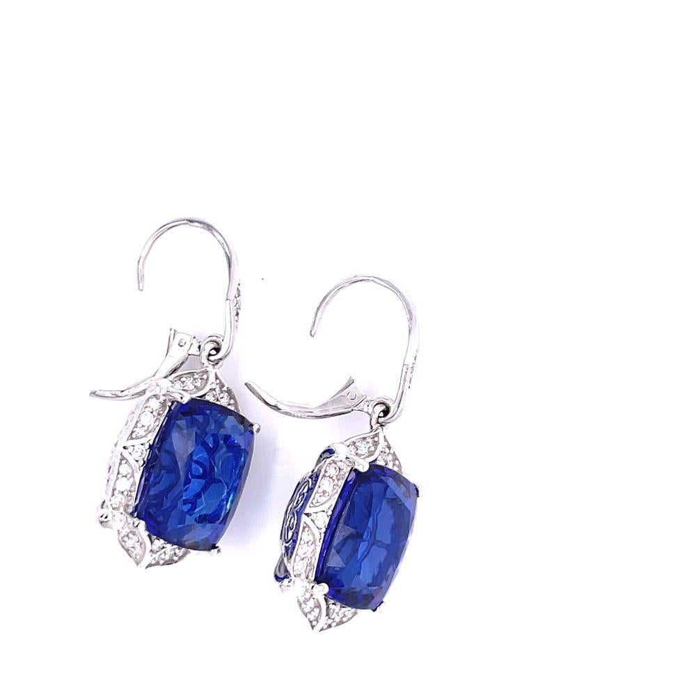18k white gold Tanzanite and diamond dangle earrings are a true masterpiece.
A total of two Tanzanites, weighing an impressive 26.86 carats, grace these earrings, radiating a mesmerizing royal blue hue. Tanzanite is a rare gemstone found exclusively