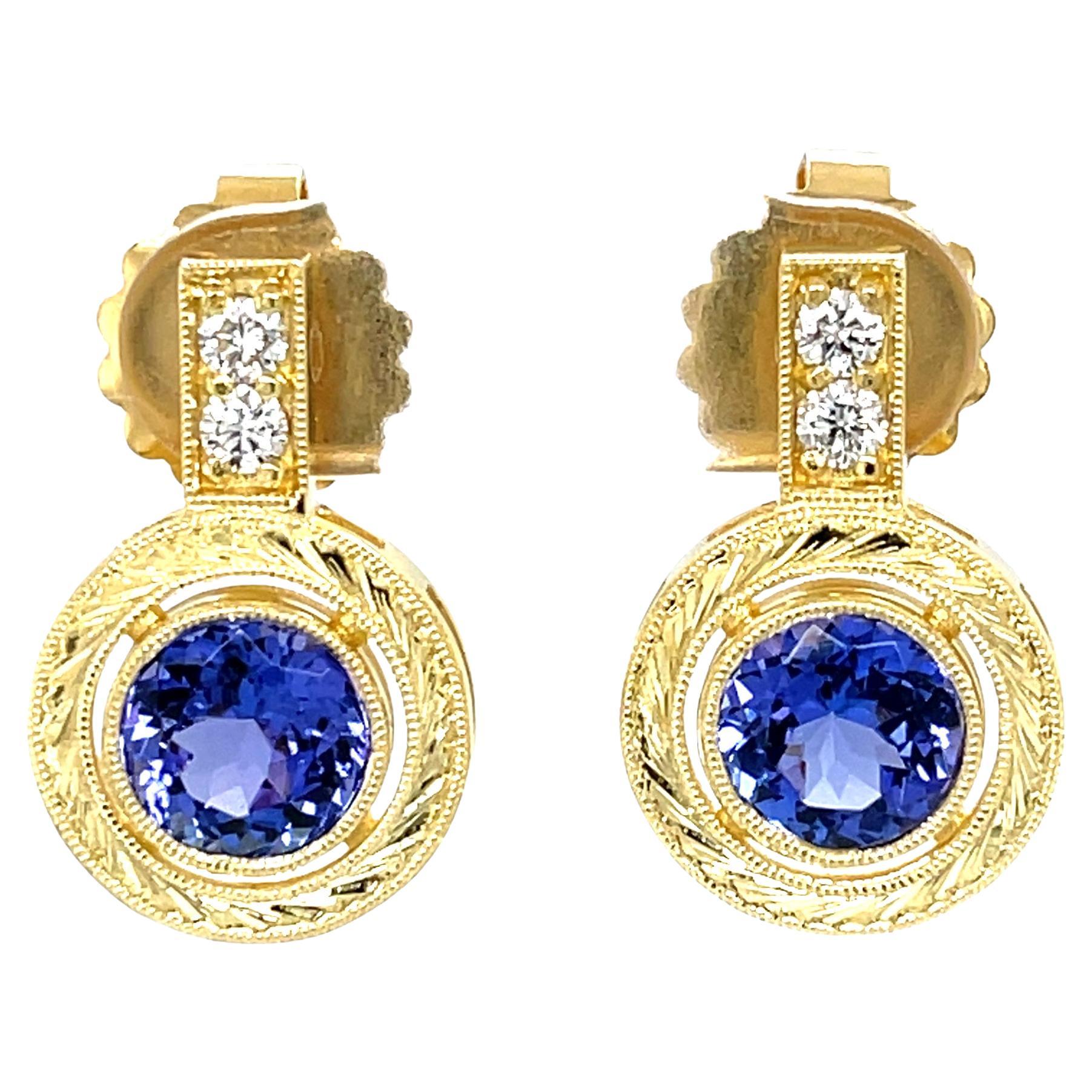 These beautiful drop earrings are set with 7mm round tanzanite that have extraordinary color and brilliance! Weighing a total of 2.94 carats these gems are quite impressive! They have been set in handmade 18k yellow gold bezels, framed by