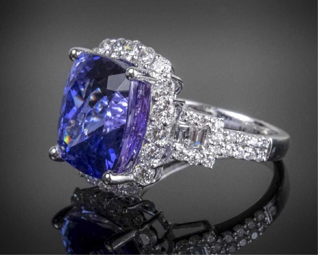 Platinum ring with a cushion mixed cut tanzanite measuring 13.49 x 11.94 x 9.92mm (12.96 carats) within a border of and accented with round diamonds. (tcw 1.80)  Size 7,  10.6 grams.