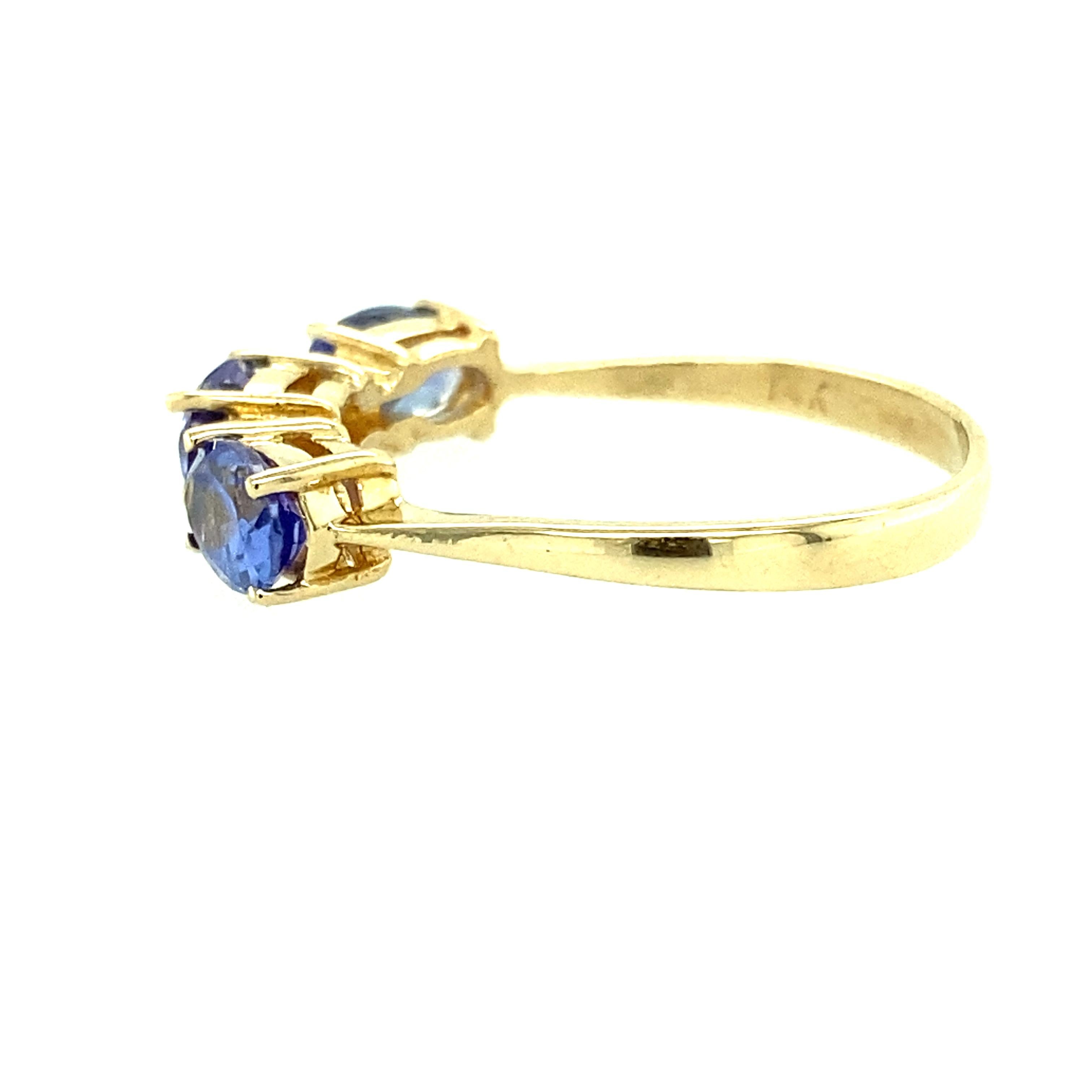One 14 karat yellow gold ring set with three 6x4 natural tanzanite stones and two brilliant cut diamonds, approximately 0.04 carat total weight with matching I-J color and I1 clarity.  The ring is a finger size 7.25.  