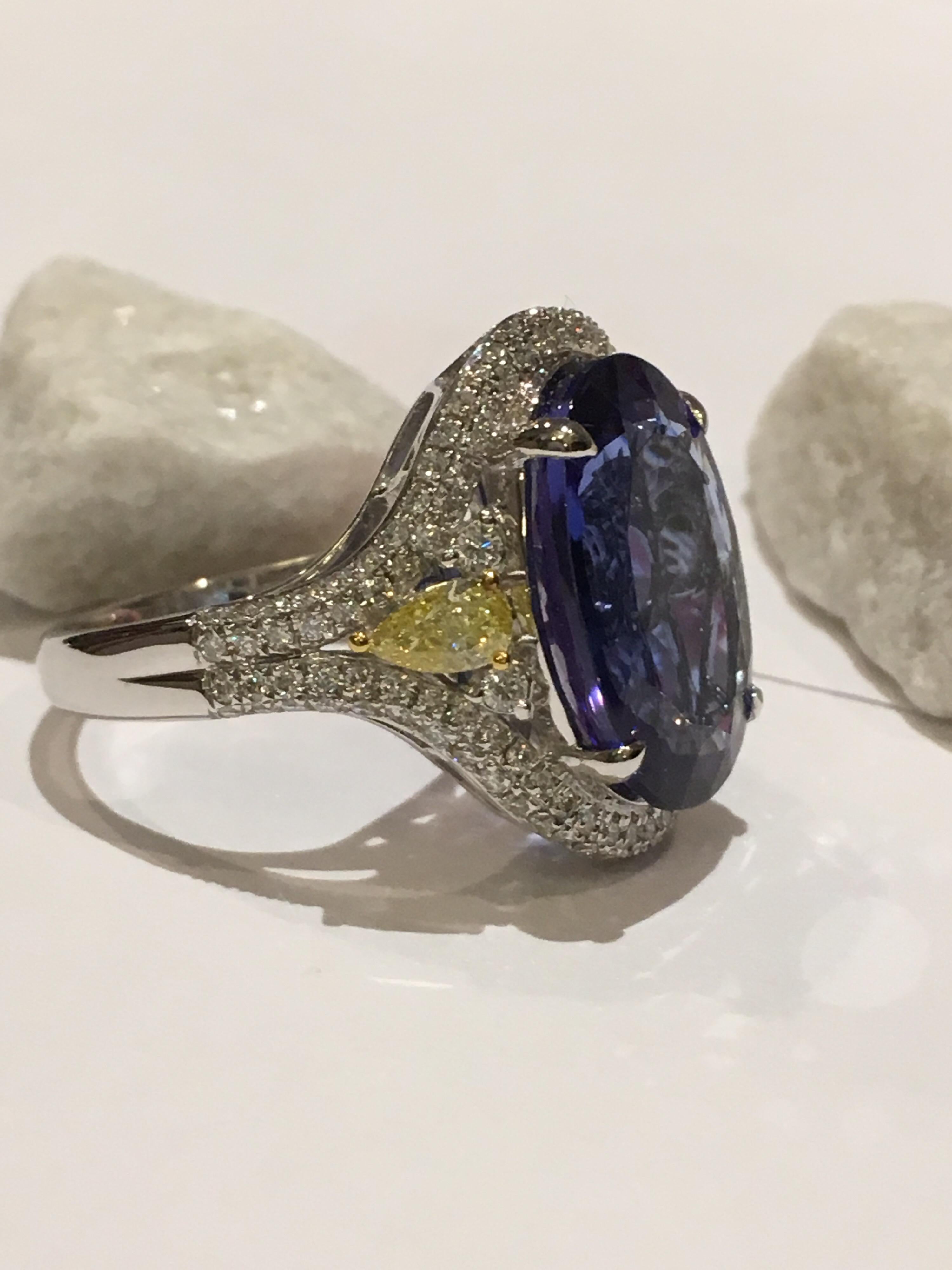 Natural AAA Quality Tanzanite is Royal Ink Blue Color set in 14K Two Tone Gold . The weight of Tanzanite is 8.94 Carat. Two Pear Shape Diamond Total weight is 0.47 Carat, White Round Diamonds are 0.69 Carat. the Size of the Ring is 7. This Ring can