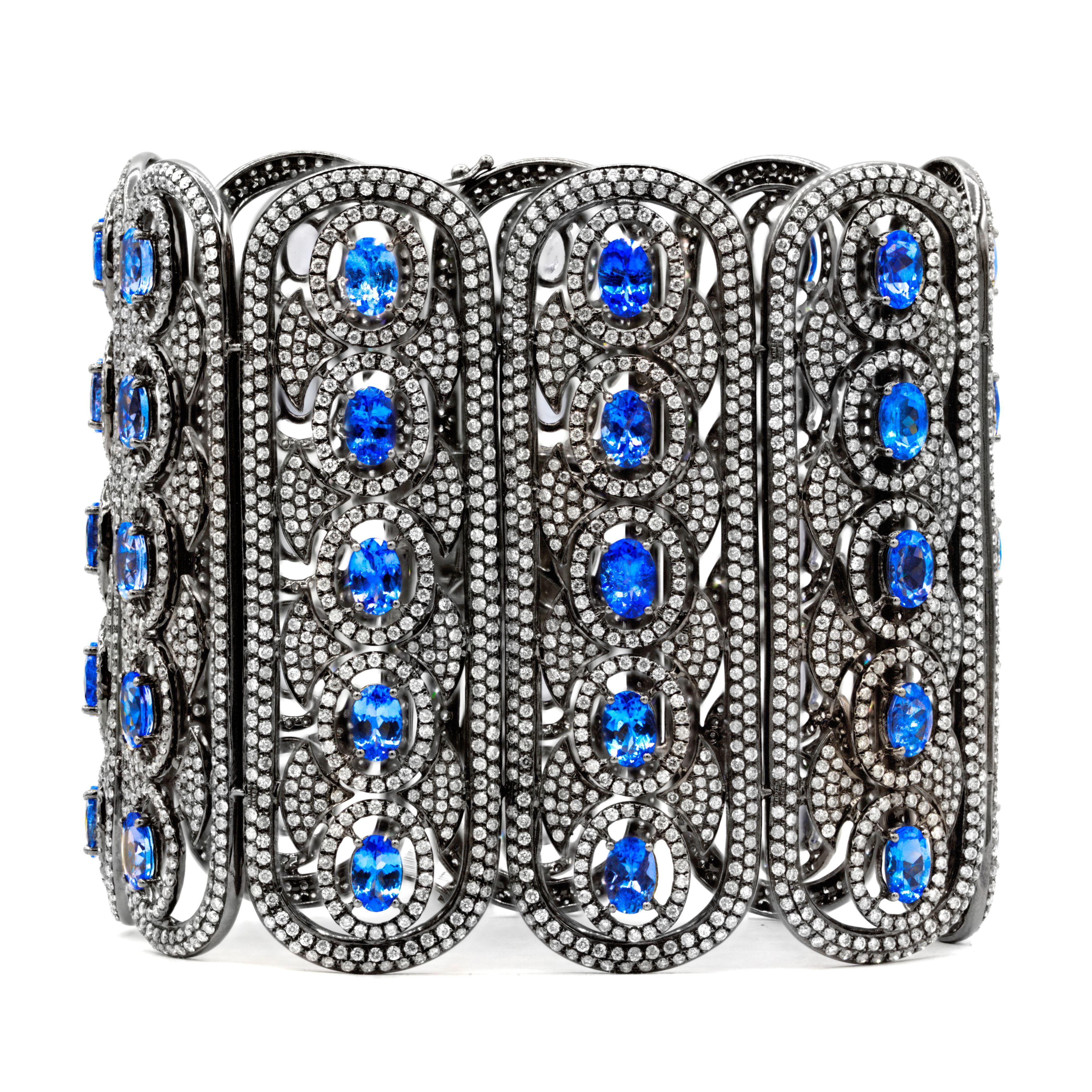 Wide 18K White gold with black rhodium soft cuff bracelet, features 22.97 Carats of Natural Tanzanites, surrounded by 20.52 Carats of Diamonds, F-G color SI in clarity. 2.5