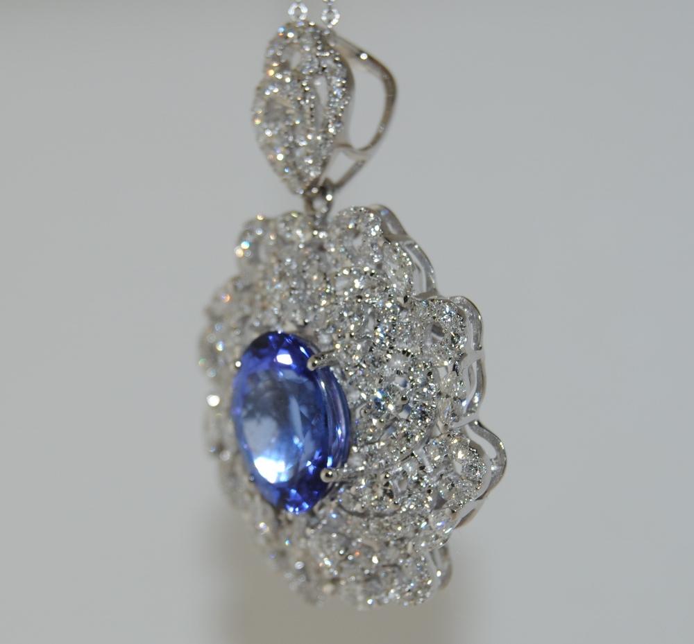 Ladies Pendant Necklace set with an Oval Shape Tanzanite weighs 3.65 carat, surrounded by Marquise and Round Brilliant White Diamonds total 2.16 carats.  This pendant is mounted in 18 Karat White Gold.  Includes chain 18 inches long.