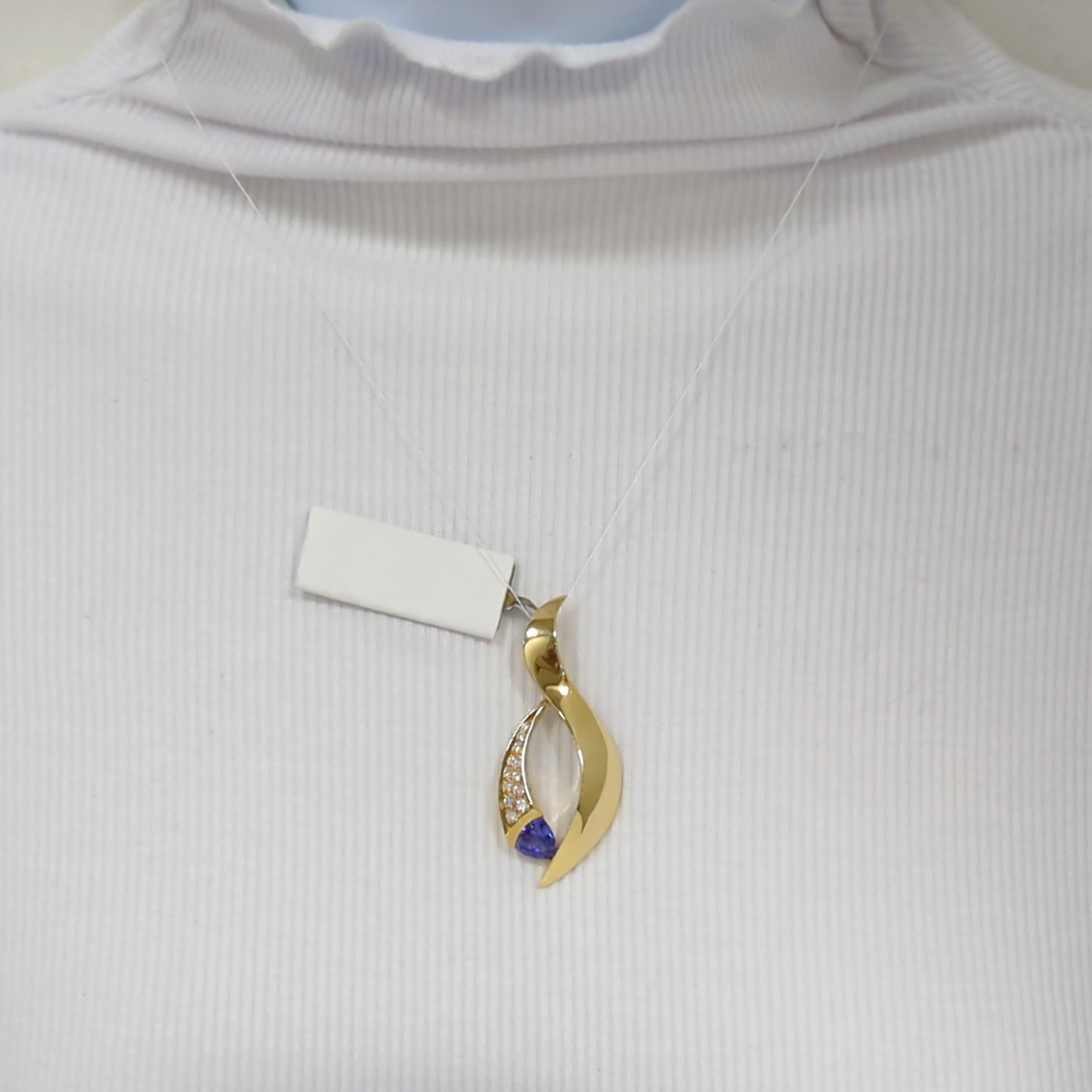 Magnifique pendentif avec un trillion de tanzanite de 0,40 ct. et des diamants blancs ronds de 0,10 ct.  Fabriqué à la main en or jaune 18k.  La chaîne peut être achetée séparément.