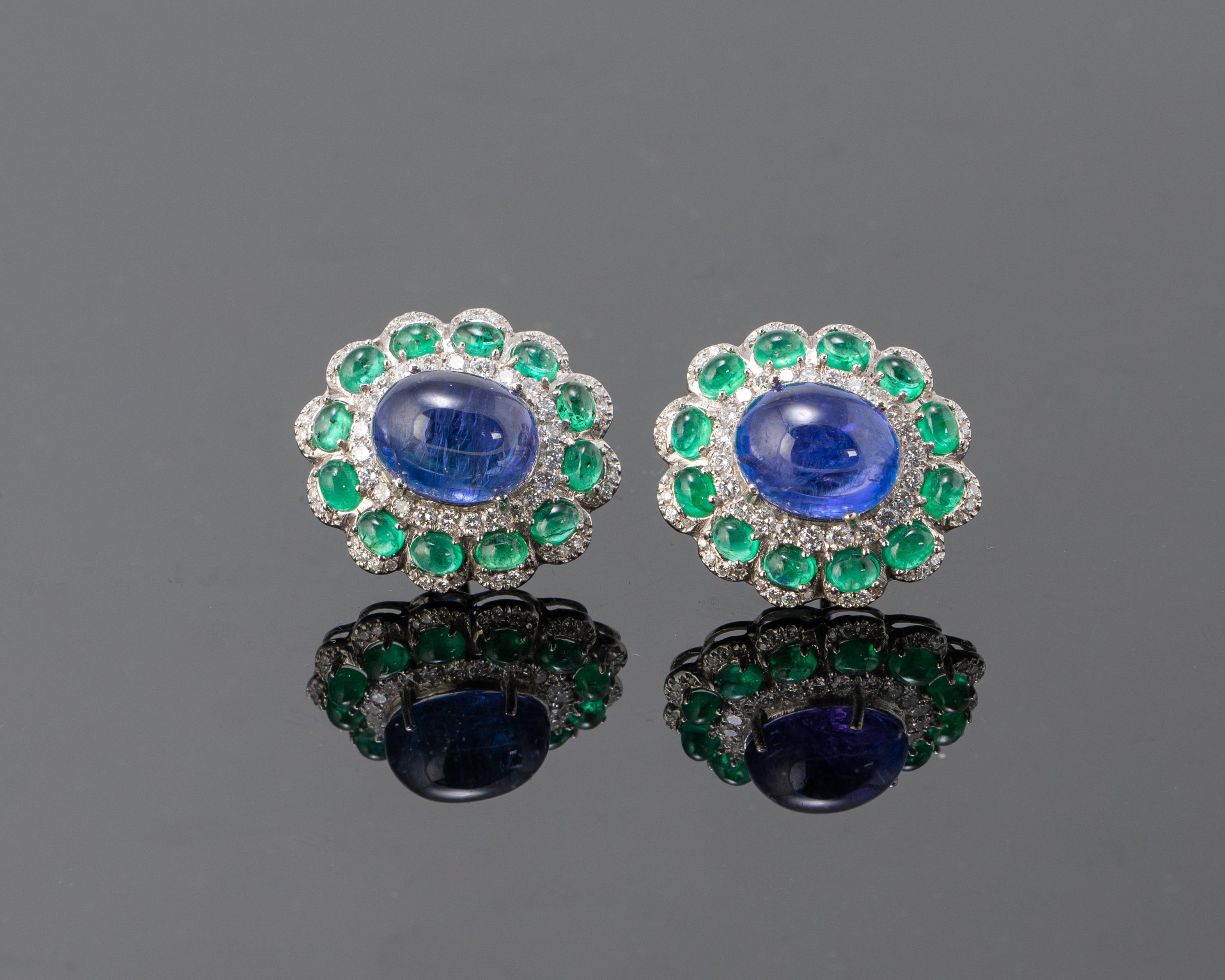 A beautiful pair of natural Tanzanite cabochons and natural Emerald cabochon earrings, all set in solid 18K white gold. These stones are transparent, with some naturally occuring inclusions, making each stone unique. The earrings come with a push