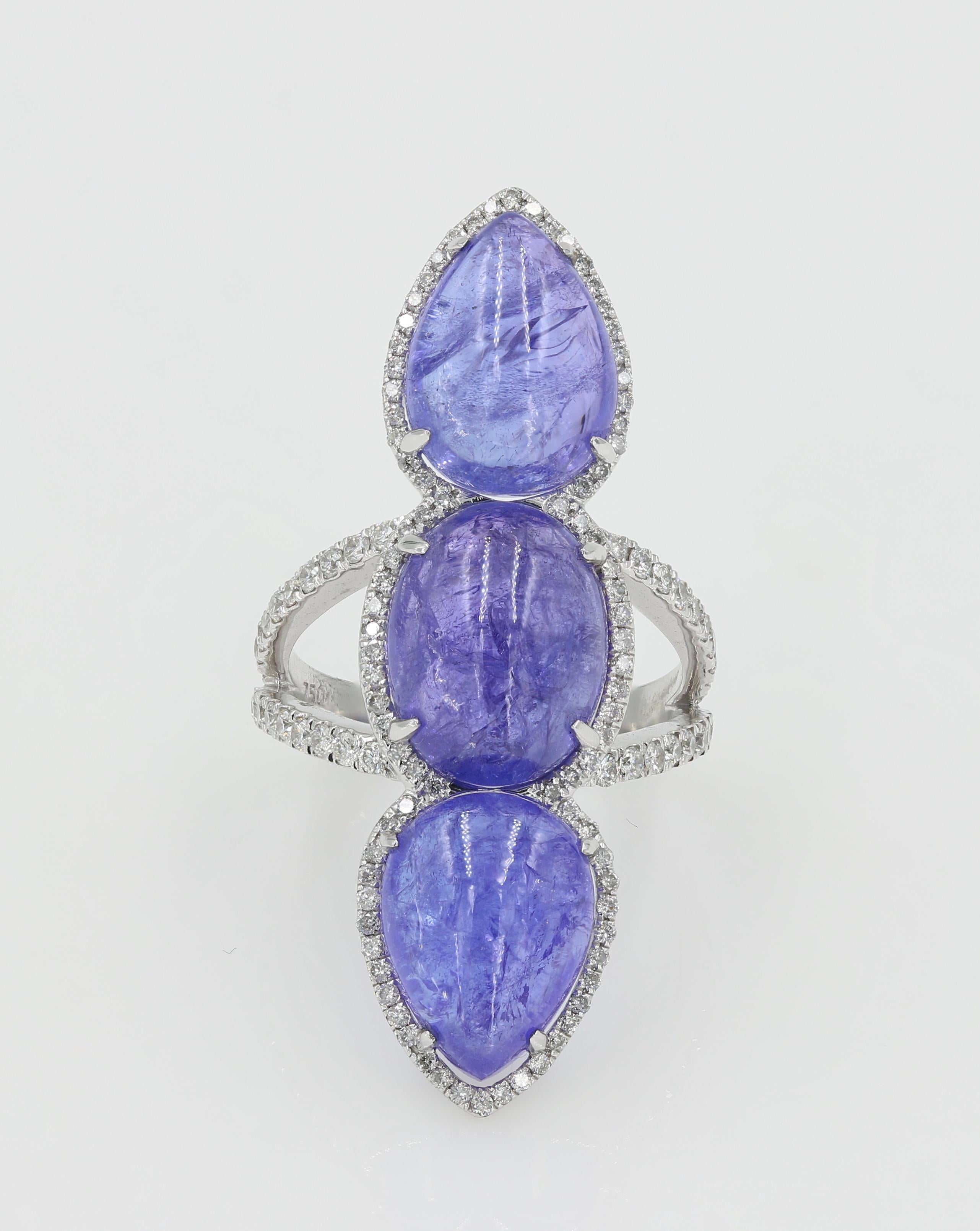 This striking shaped Tanzanite Cabochon cut ring features 3 Tanzanite Cabochon cuts weighing 19.20cts. total. Each cabochon is beautifully framed with diamonds which continue halfway along a split shank. 130 Round diamonds weighing 0.93ct.