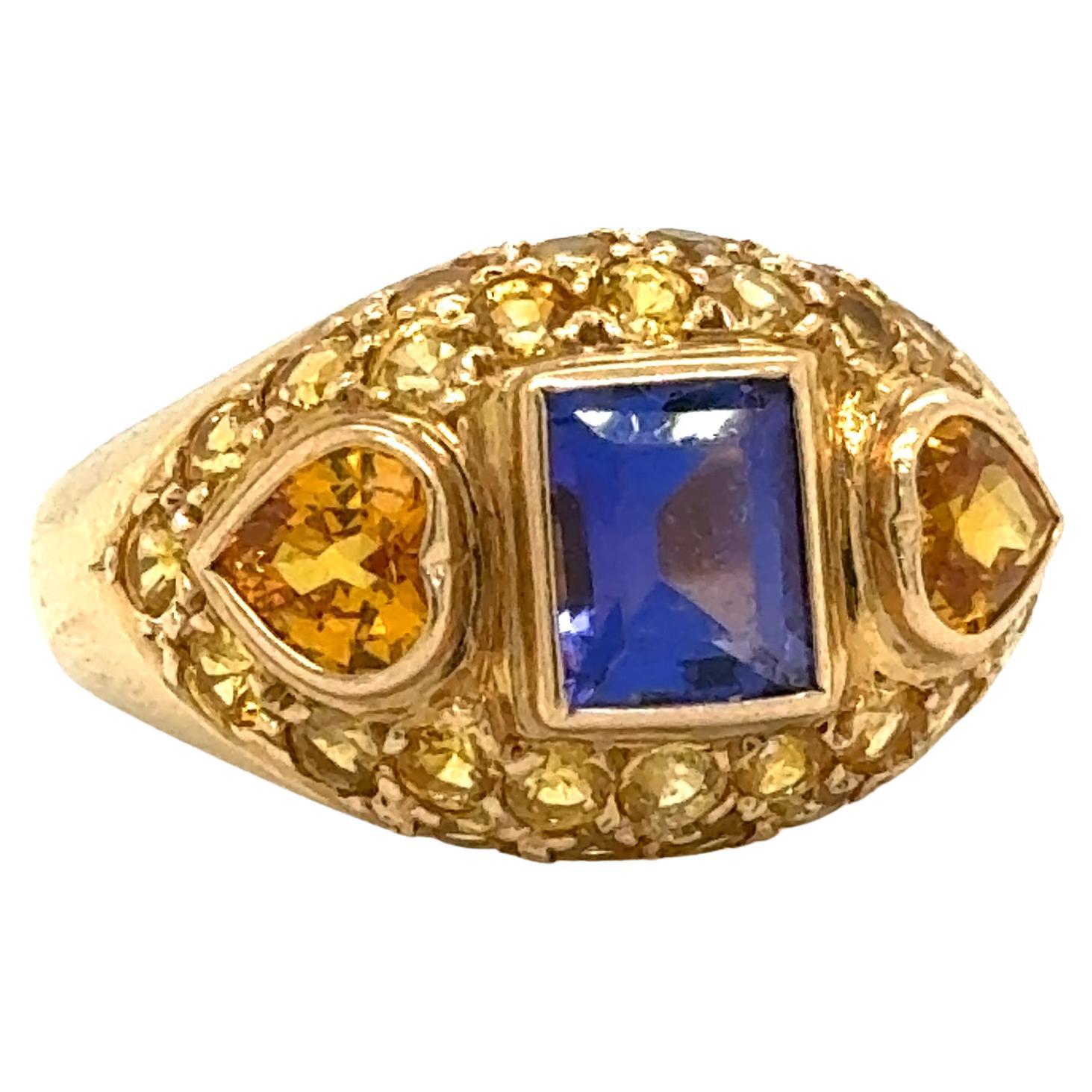 Schöner Ring in 14k Gelbgold gefertigt. Dieser Ring leuchtet in Farbe, da ein elektrisch violettblauer Tansanit die Mitte hervorhebt. Der Tansanit ist in einem Smaragd geschliffen  Form und Lünette in das Design integriert. Der Tansanit-Edelstein