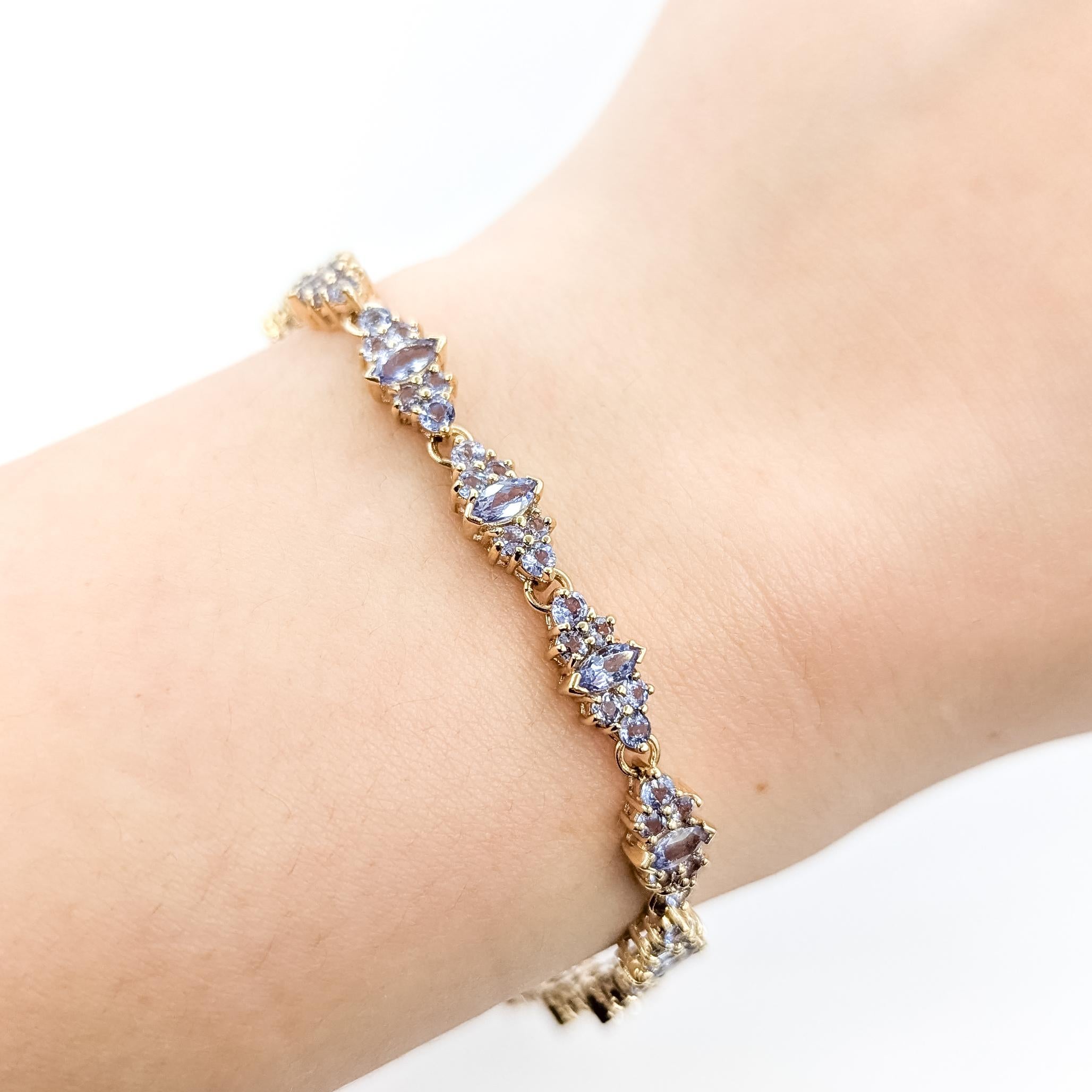 Tansanit-Cluster-Armband aus 14k Gelbgold

Dieses Armband ist aus 14-karätigem Gelbgold gefertigt und besteht aus 8,25 Karat Tansaniten, die in einem zarten Cluster angeordnet sind. Das Design kombiniert Tansanite im Marquise- und im Rundschliff und