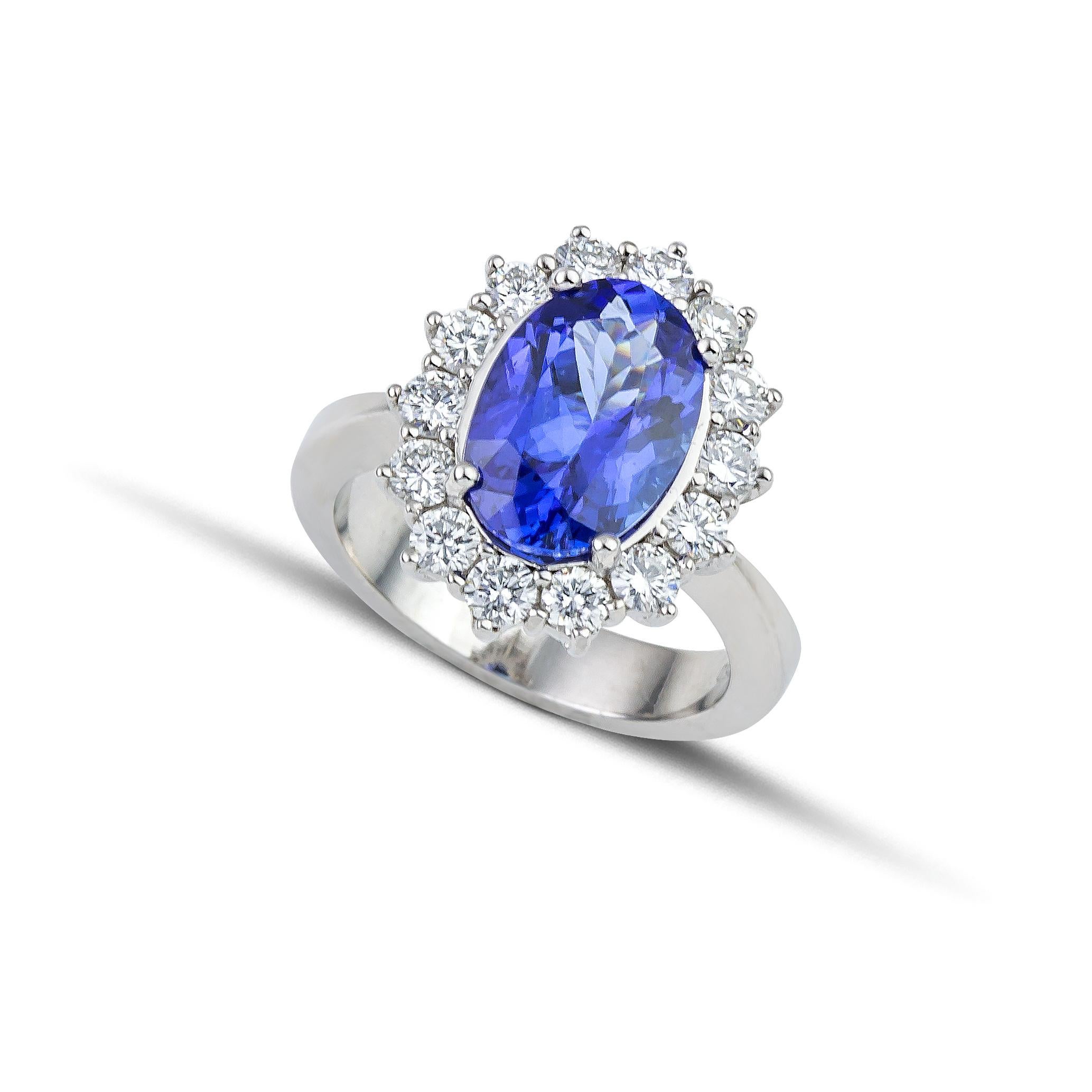 Tanzanite Diamond Cluster ring handcrafted in 18Kt white gold with a big oval blue Tanzanite and  brilliant cut diamonds. 
Inspired by the greek blue sea and its white foam, Nicofilimon designed this breathtaking jewelry piece, guaranteed to win
