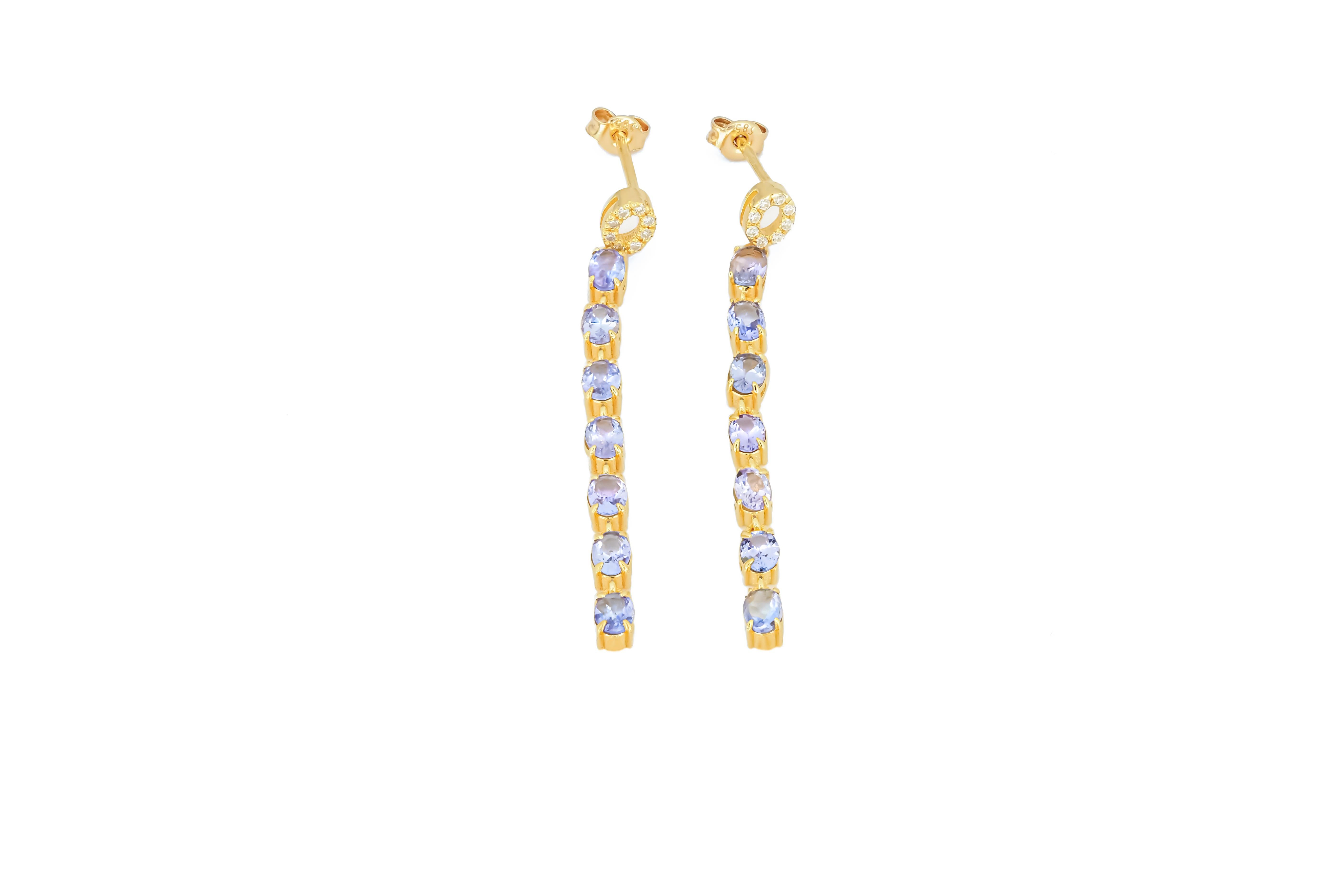 Modern Tanzanite dangle earrings studs in 14k gold. For Sale